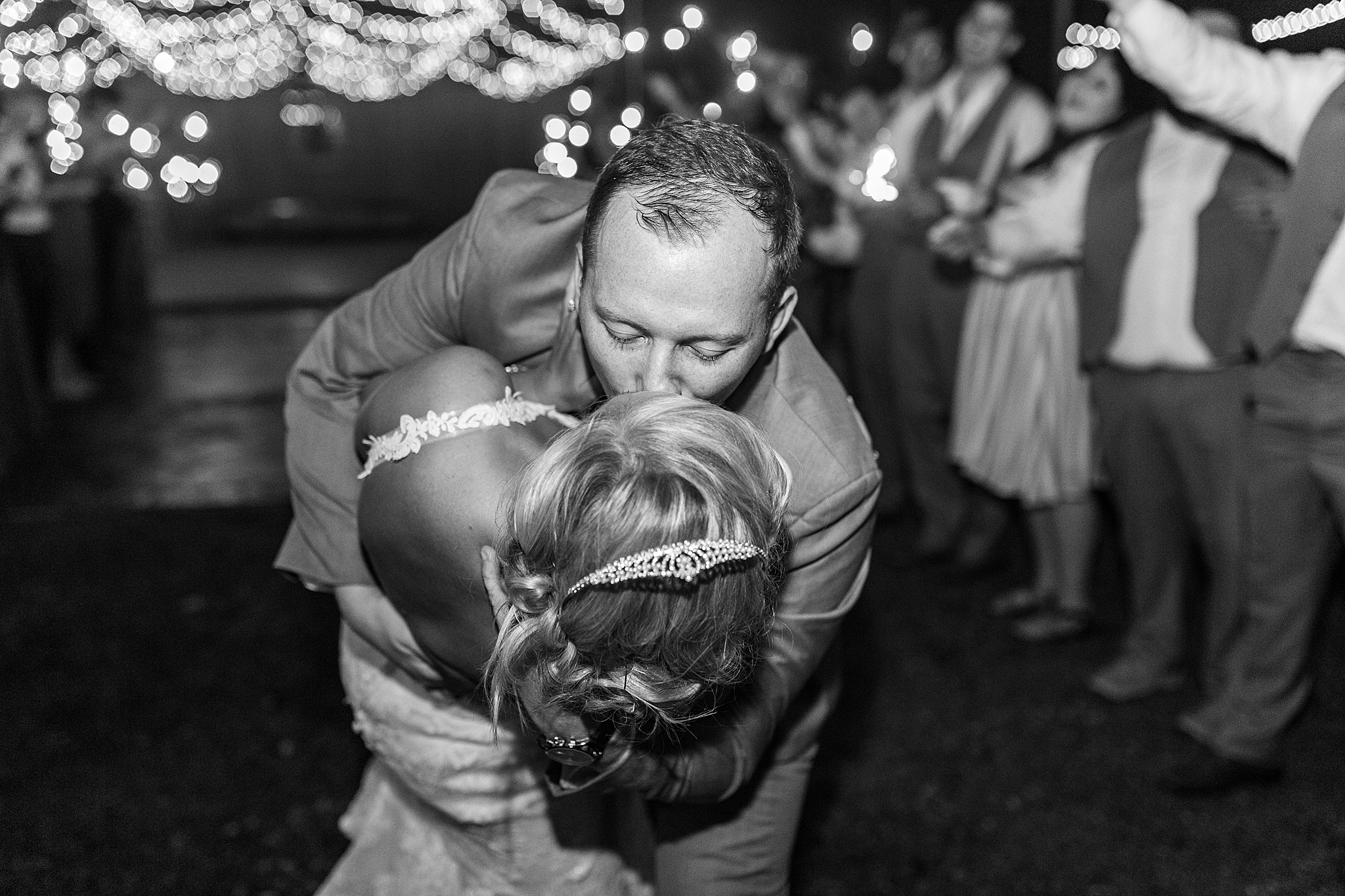 groom kisses bride during sparkler exit