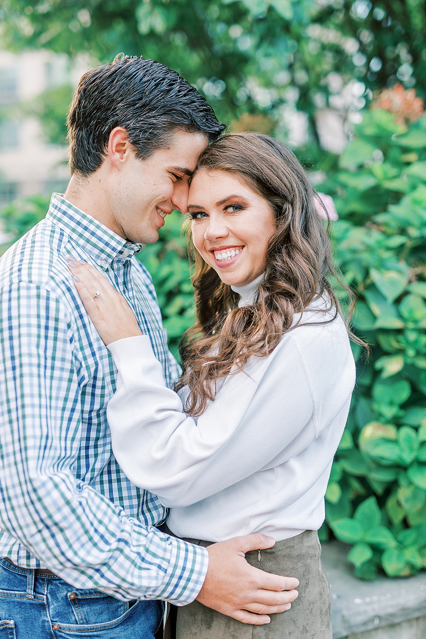 groom leans against bride's head during Romare Bearden Park engagement photos