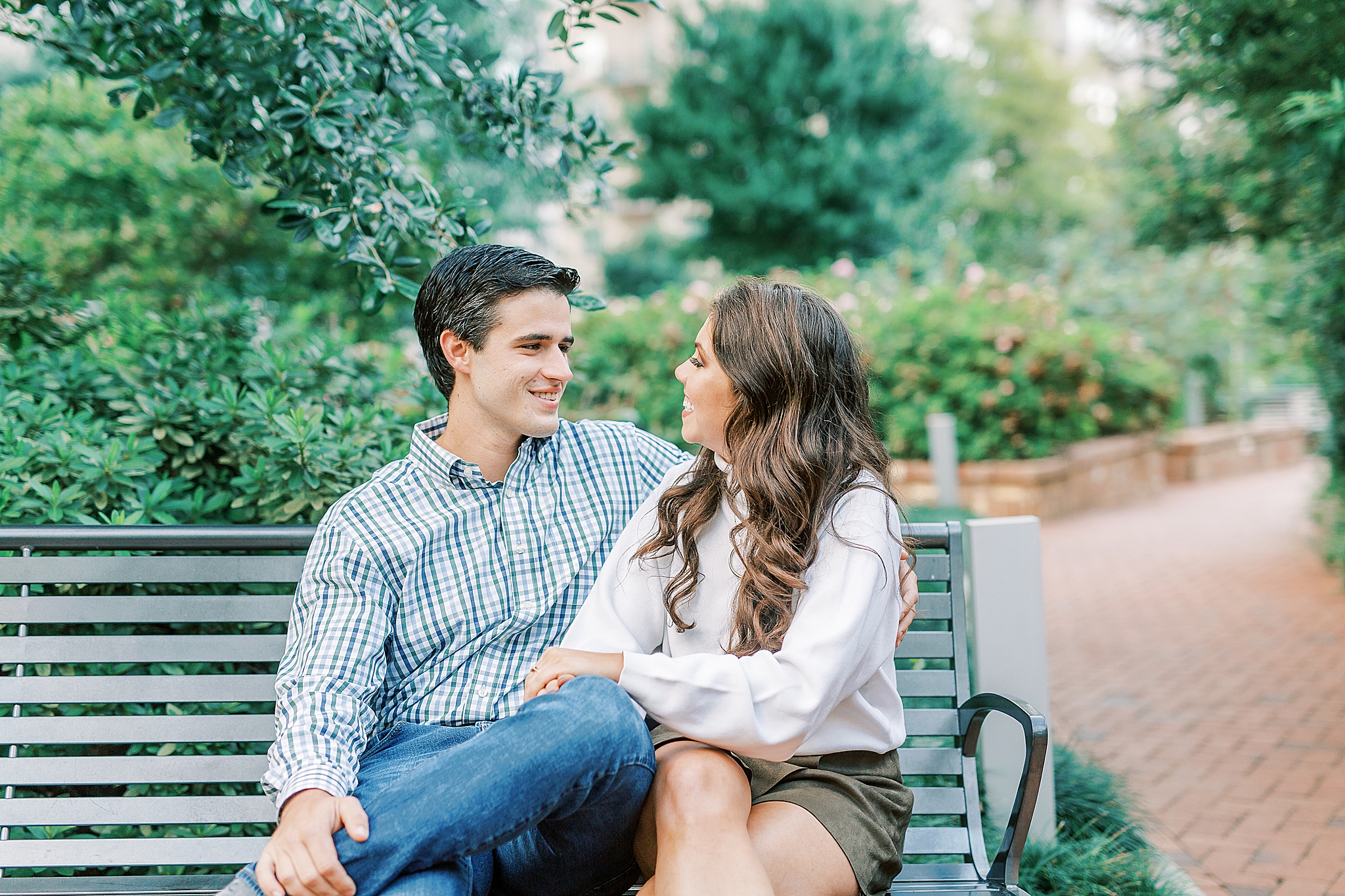 couple sits on park bench in uptown CLT