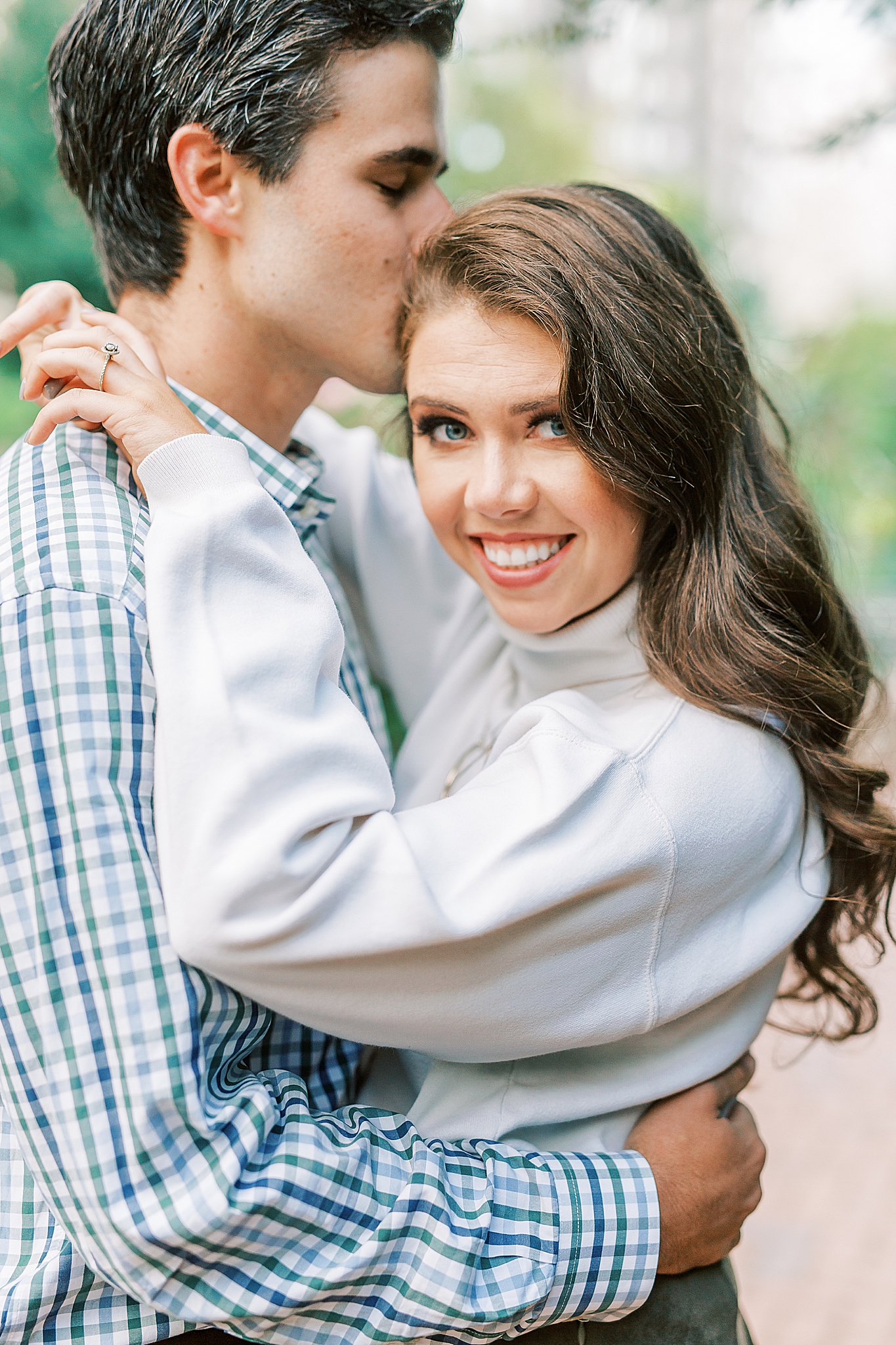 groom kisses bride's forehead during city engagement session