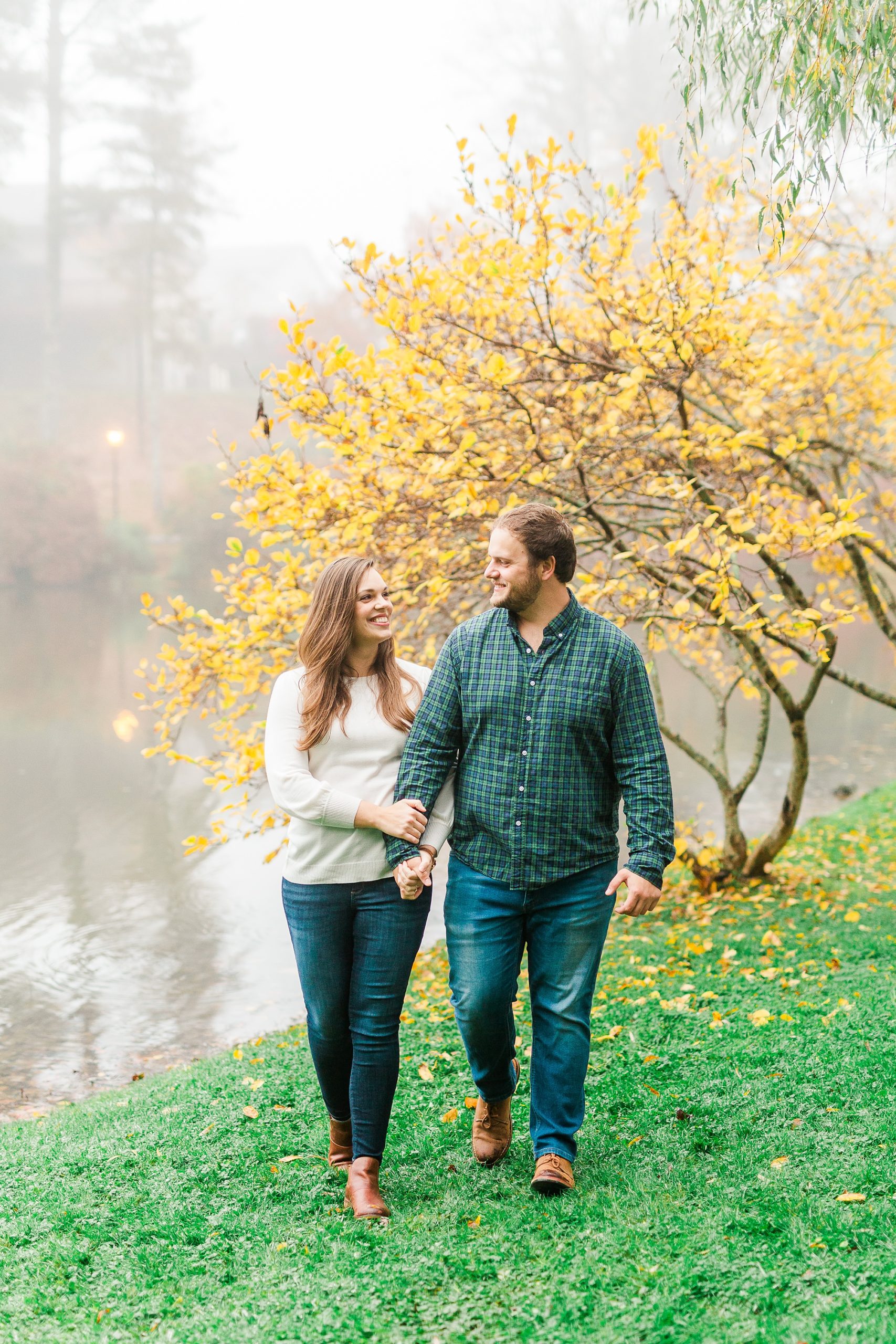 couple walks in front of yellow tree in Blowing Rock NC
