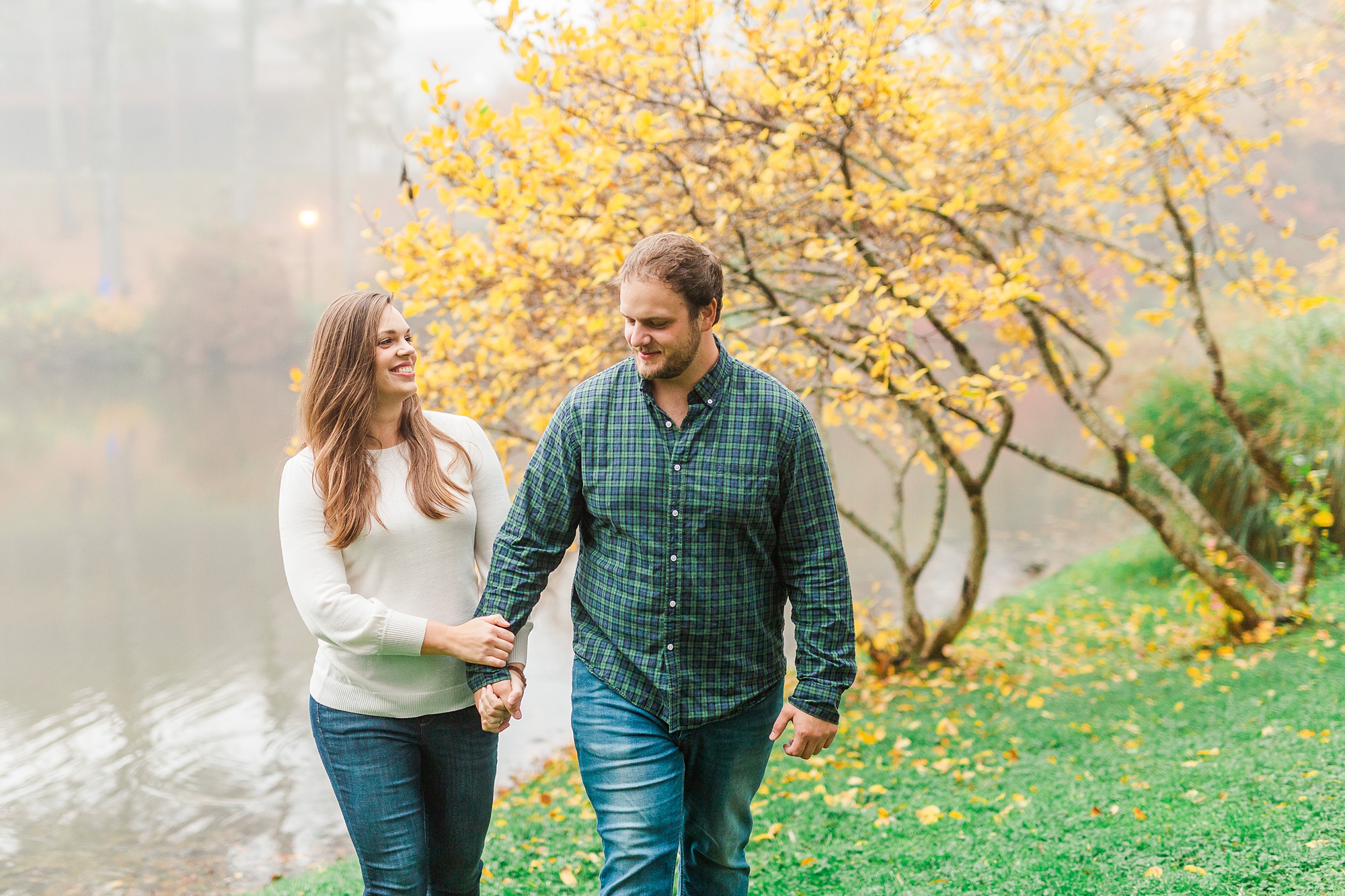 bride smiles at groom while walking by yellow tree