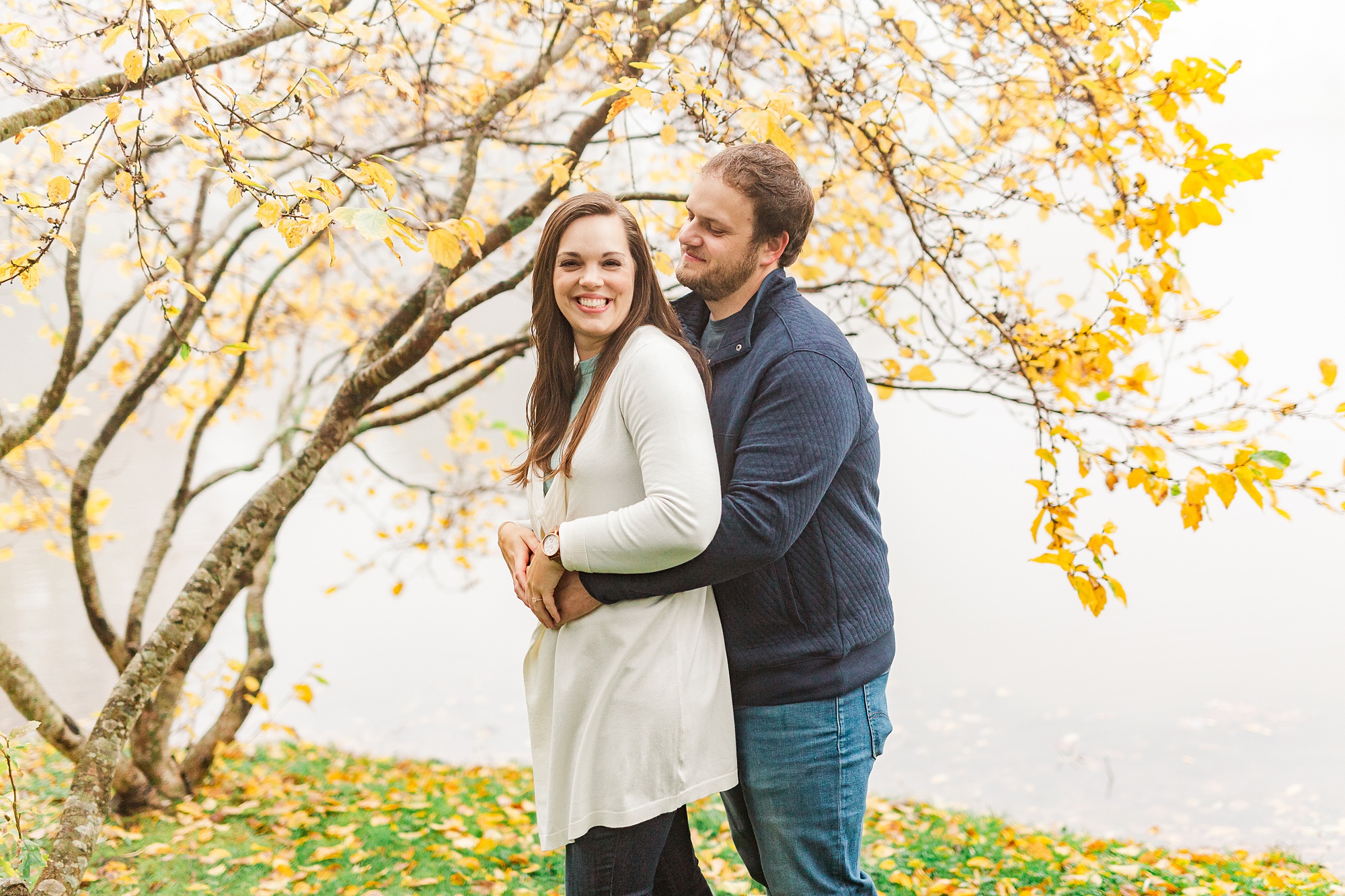 groom hugs bride from behind during engagement photos