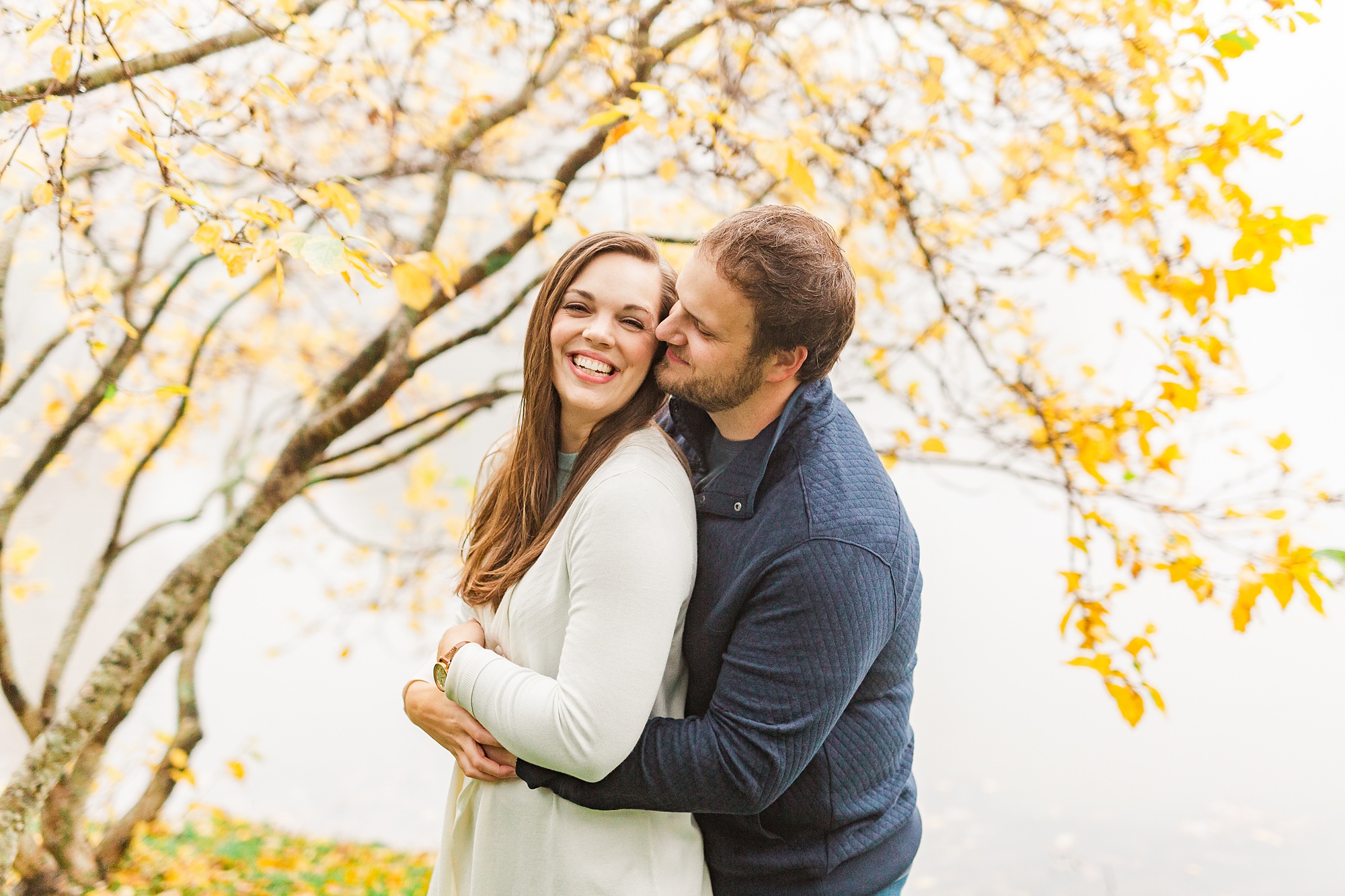 groom kisses bride's cheek during NC engagement photos