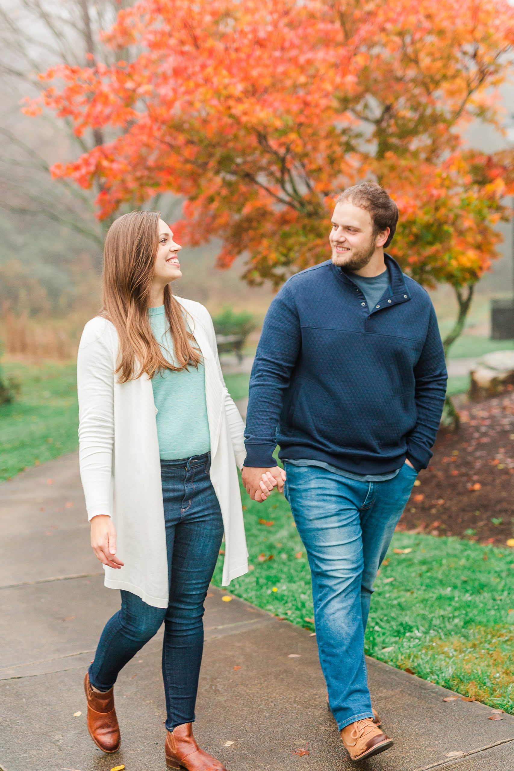 engaged couple walks through park