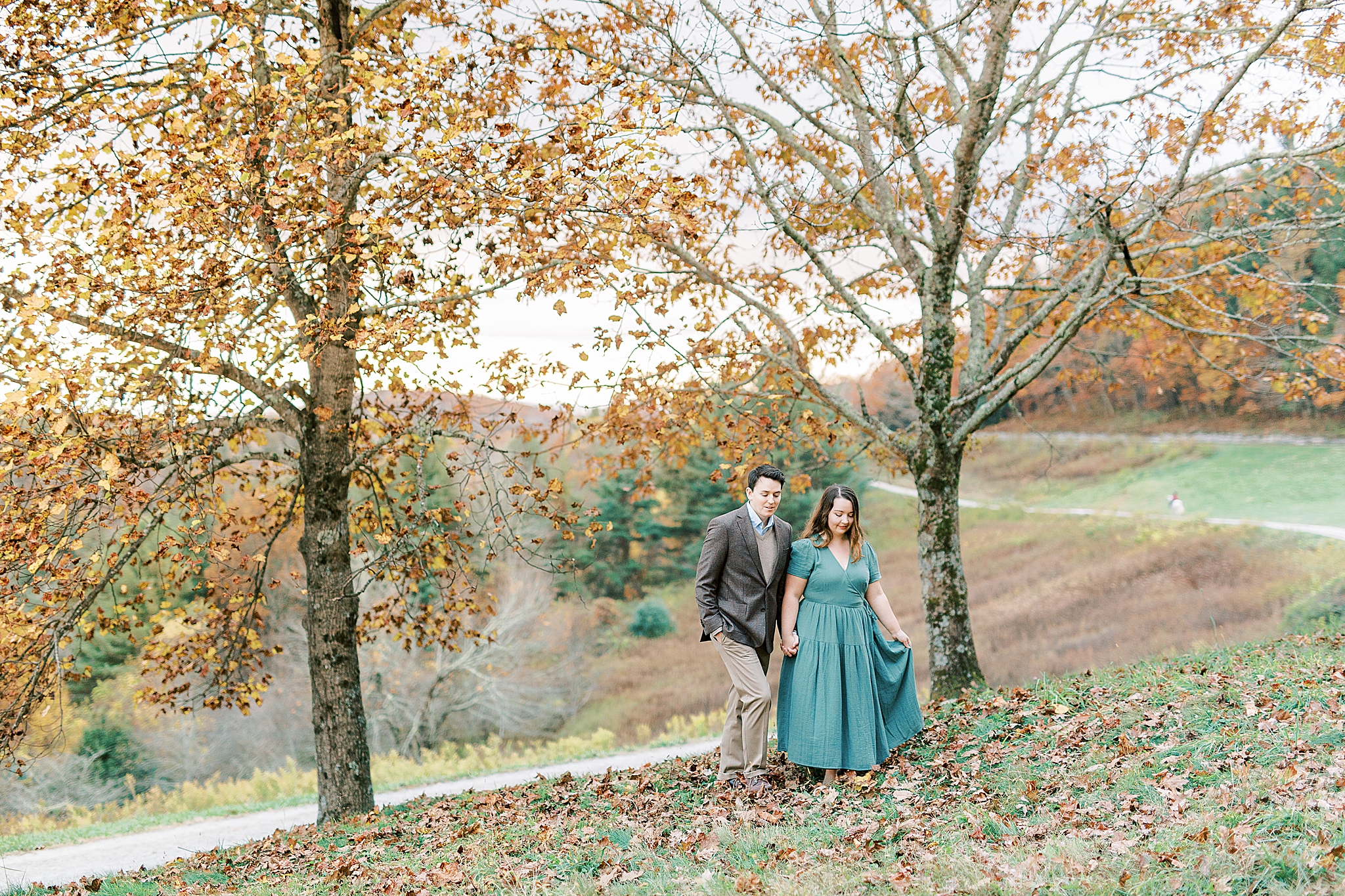 engaged couple walks along grounds of Moses Cone Manor