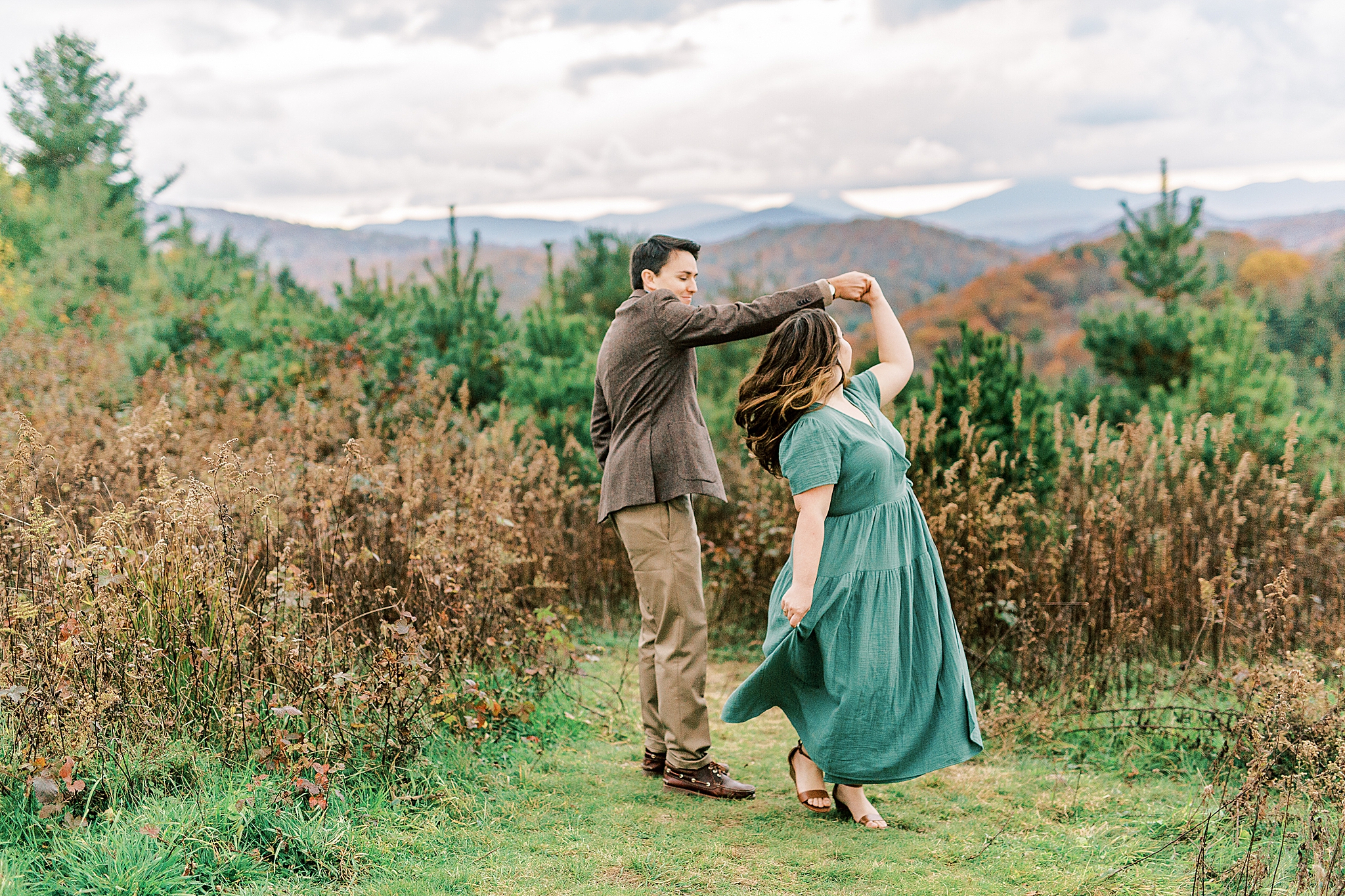 groom twirls bride during Boone NC engagement photos