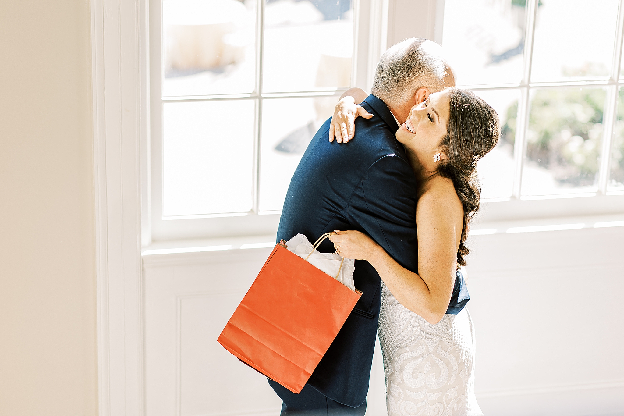 bride hugs dad and gives gift during first look