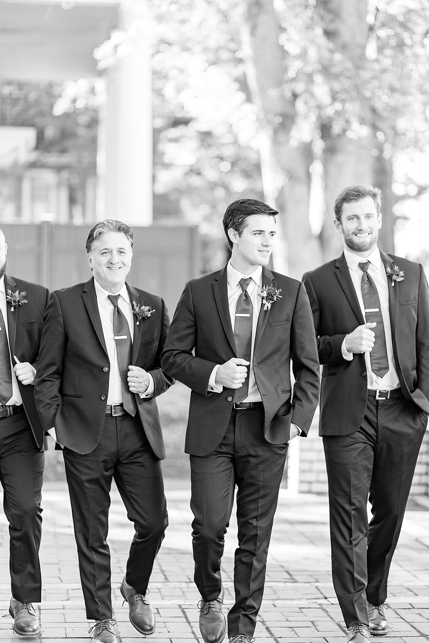 groomsmen walk outside Separk Mansion with groom