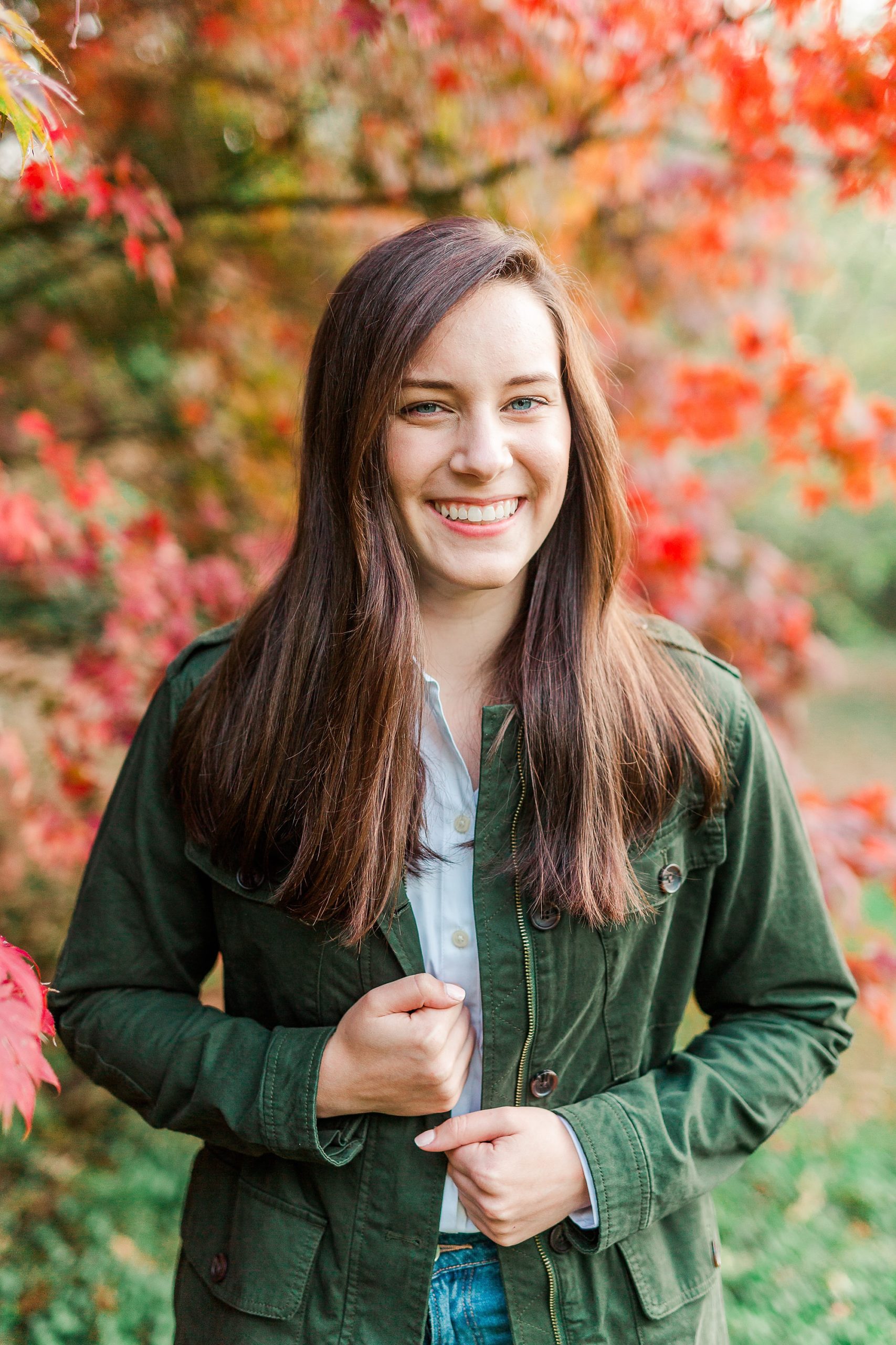senior holds green jacket during senior photos