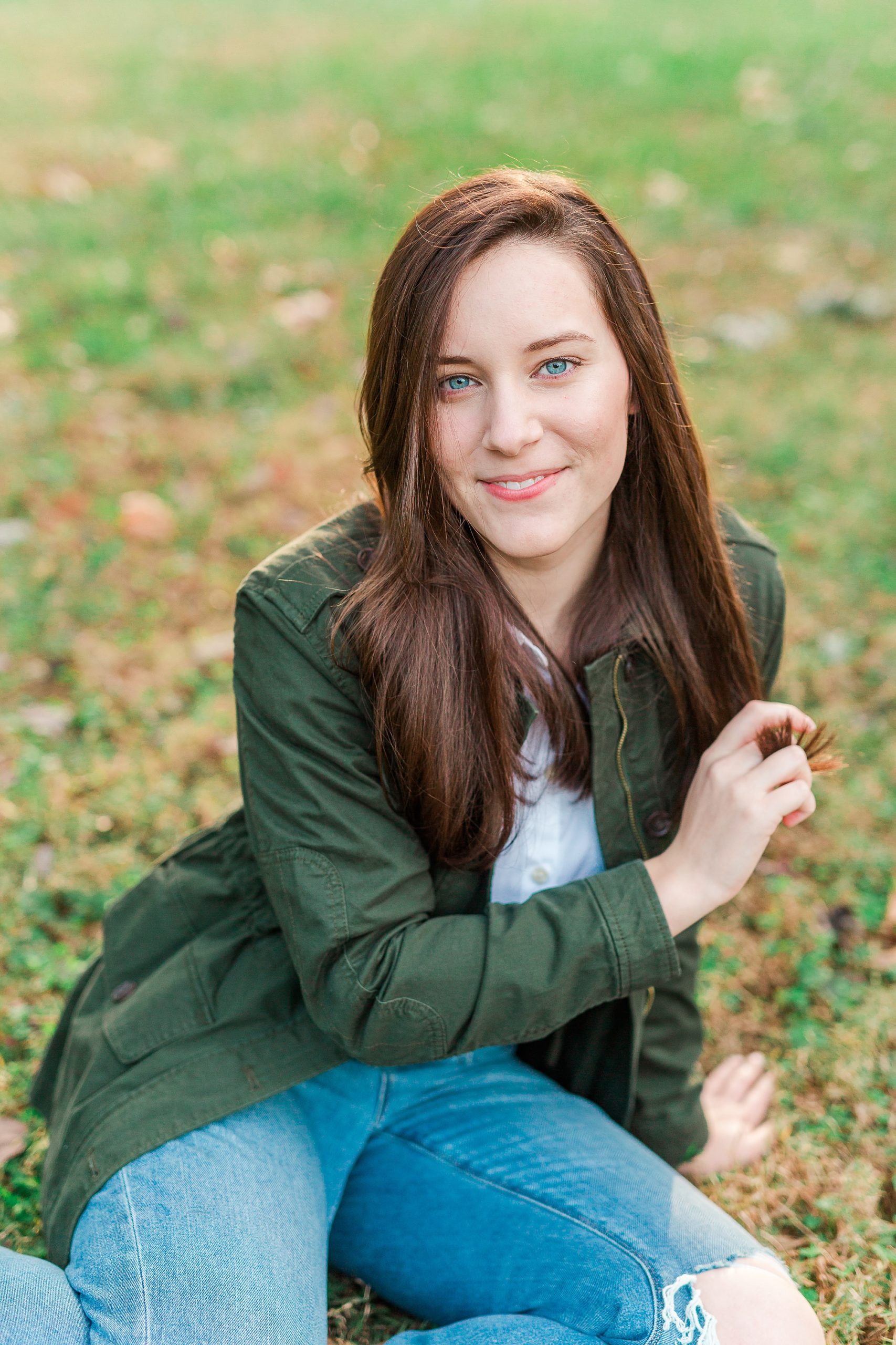 senior runs fingers through hair during senior photos at Sloan Park