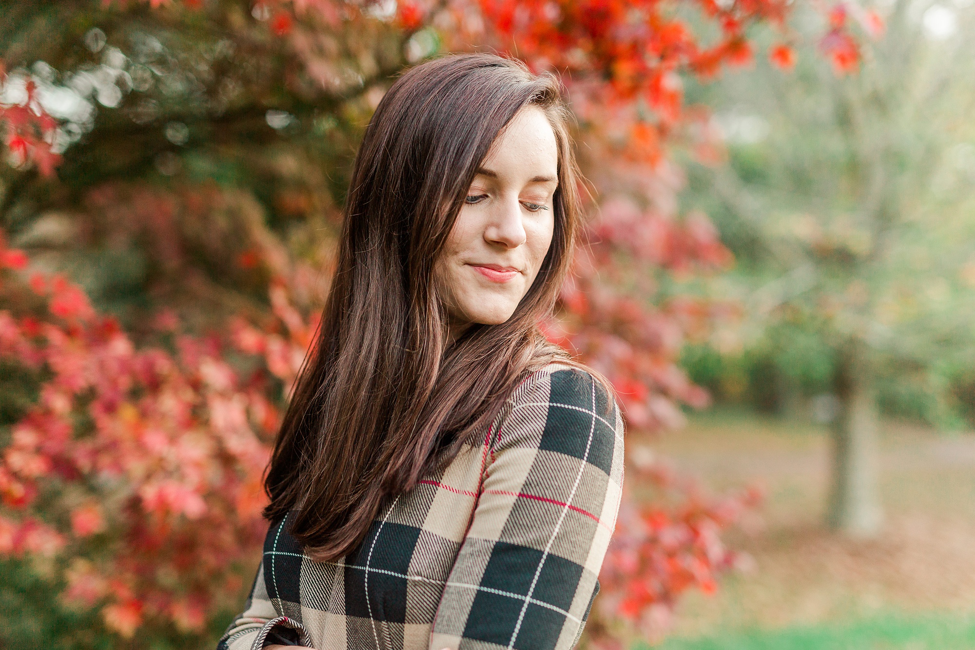 senior looks over shoulder in plaid dress
