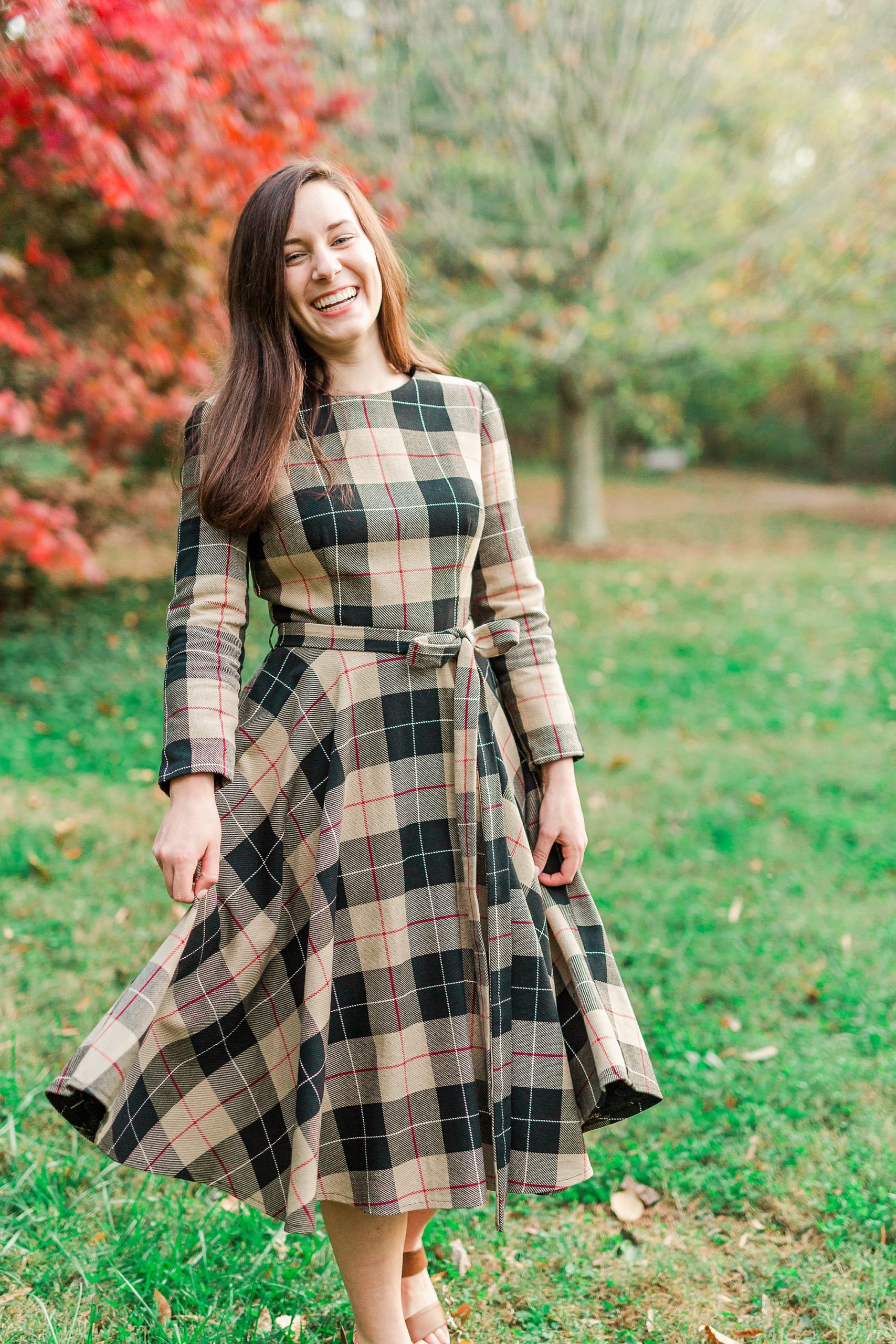 senior in plaid dress walks through Sloan Park