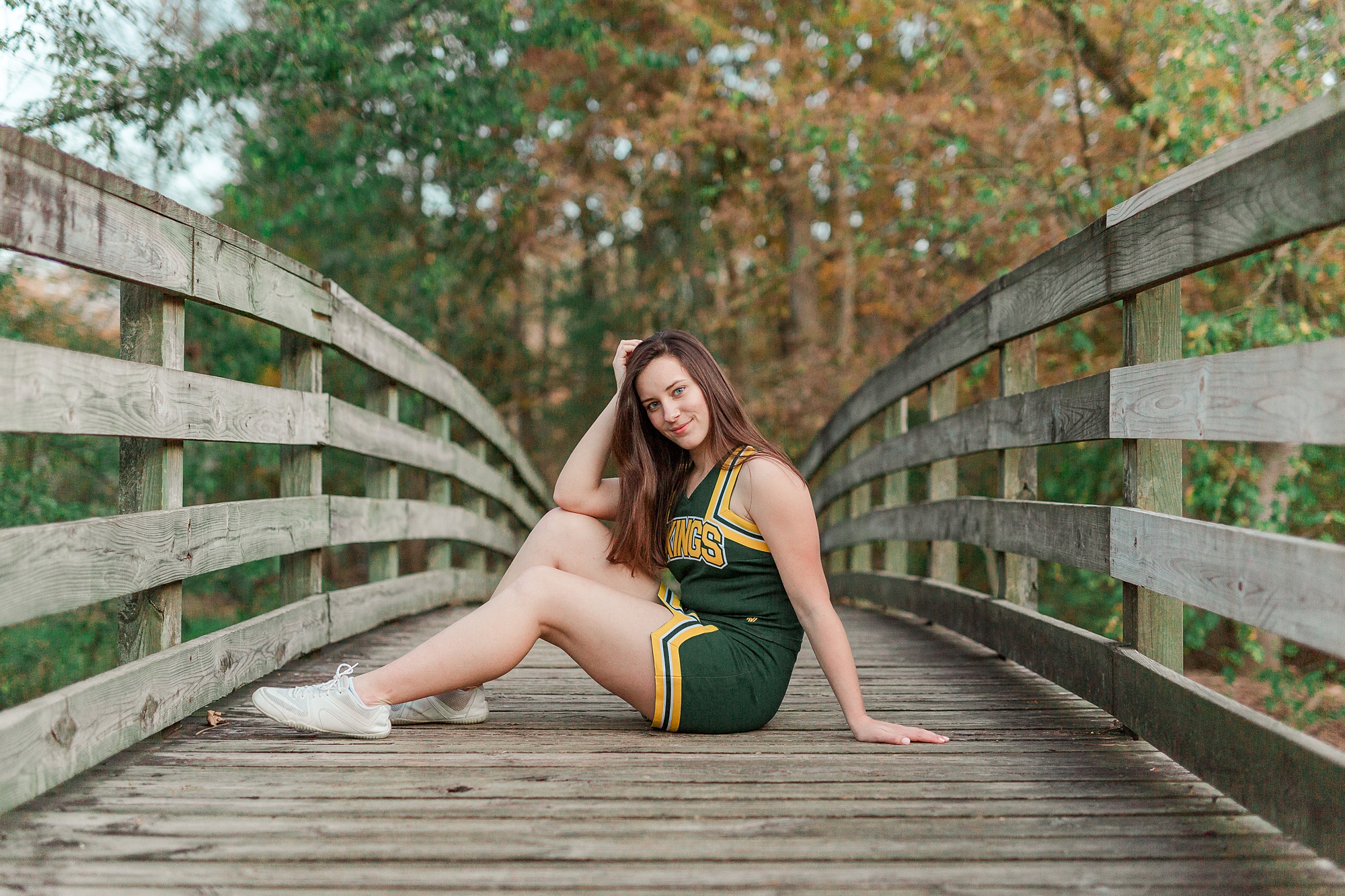 senior portraits in cheerleading outfit on bridge