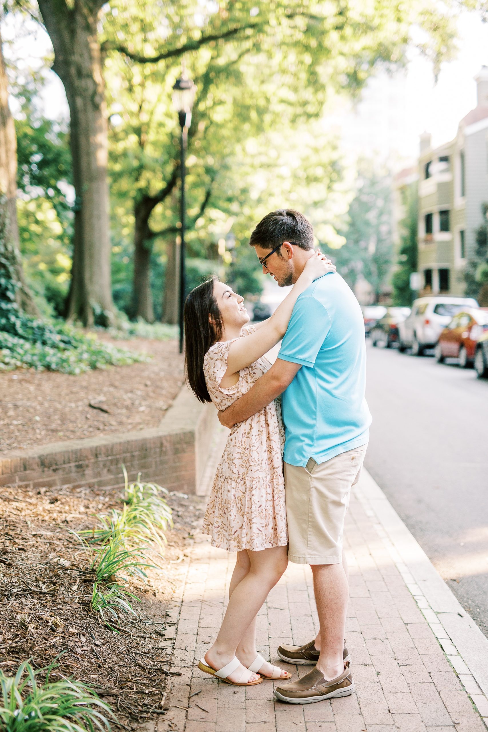 couple stands together on sidewalk in Fourth Ward Park