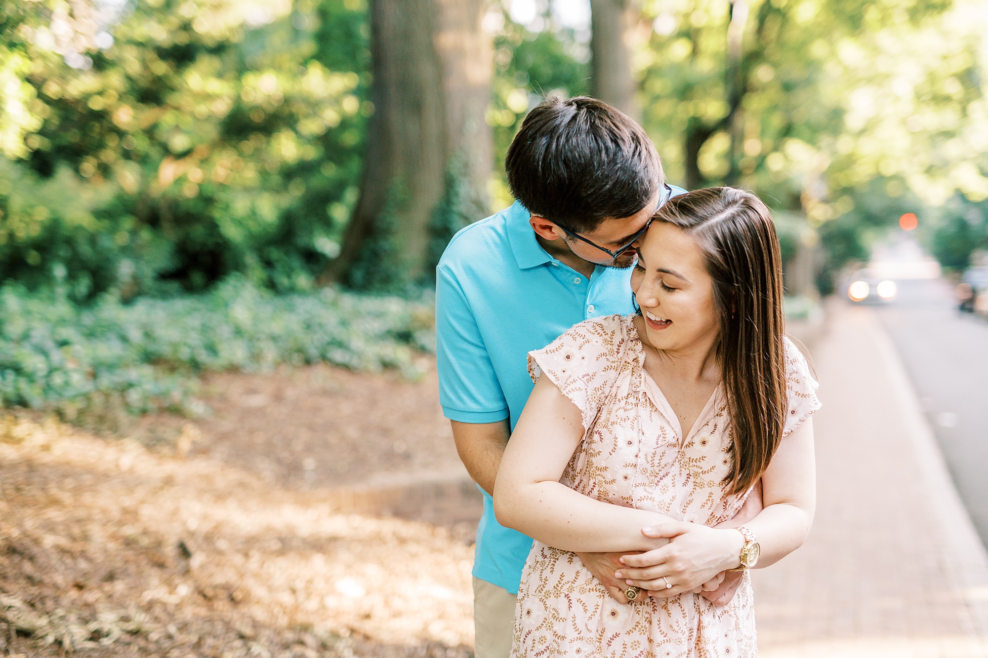 groom hugs bride from behind during Fourth Ward Park engagement photos