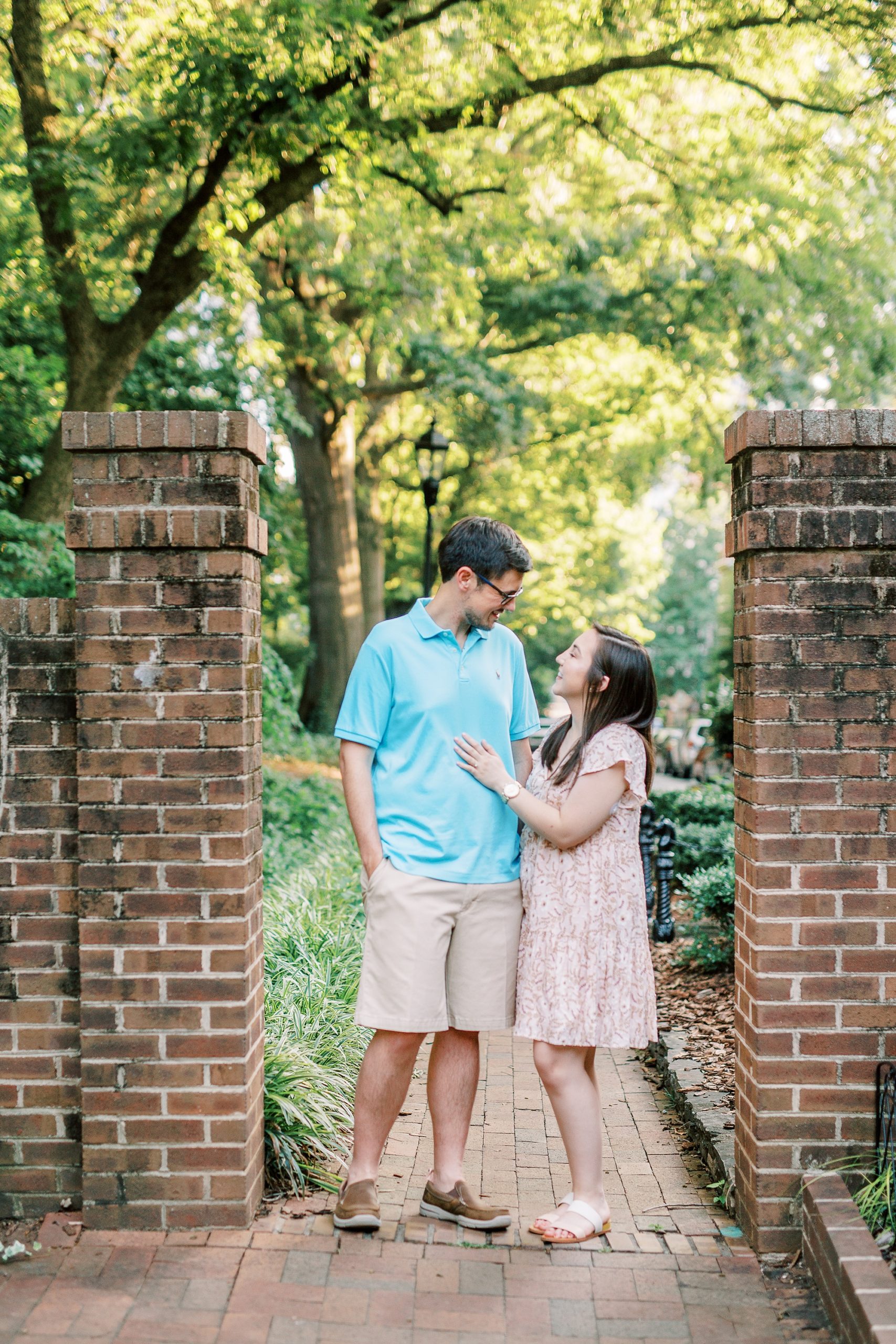 couple poses at gates of Fourth Ward Park