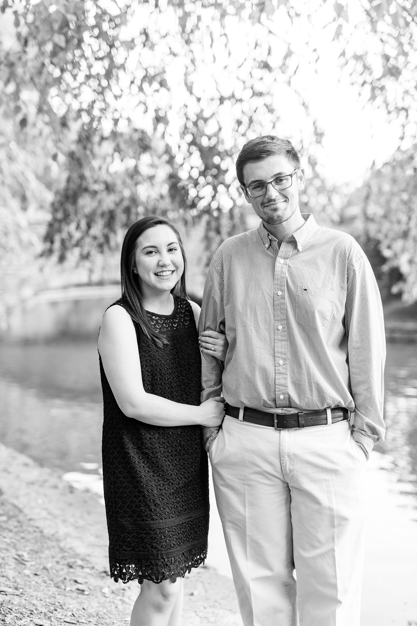 engaged couple poses by lake in Freedom Park