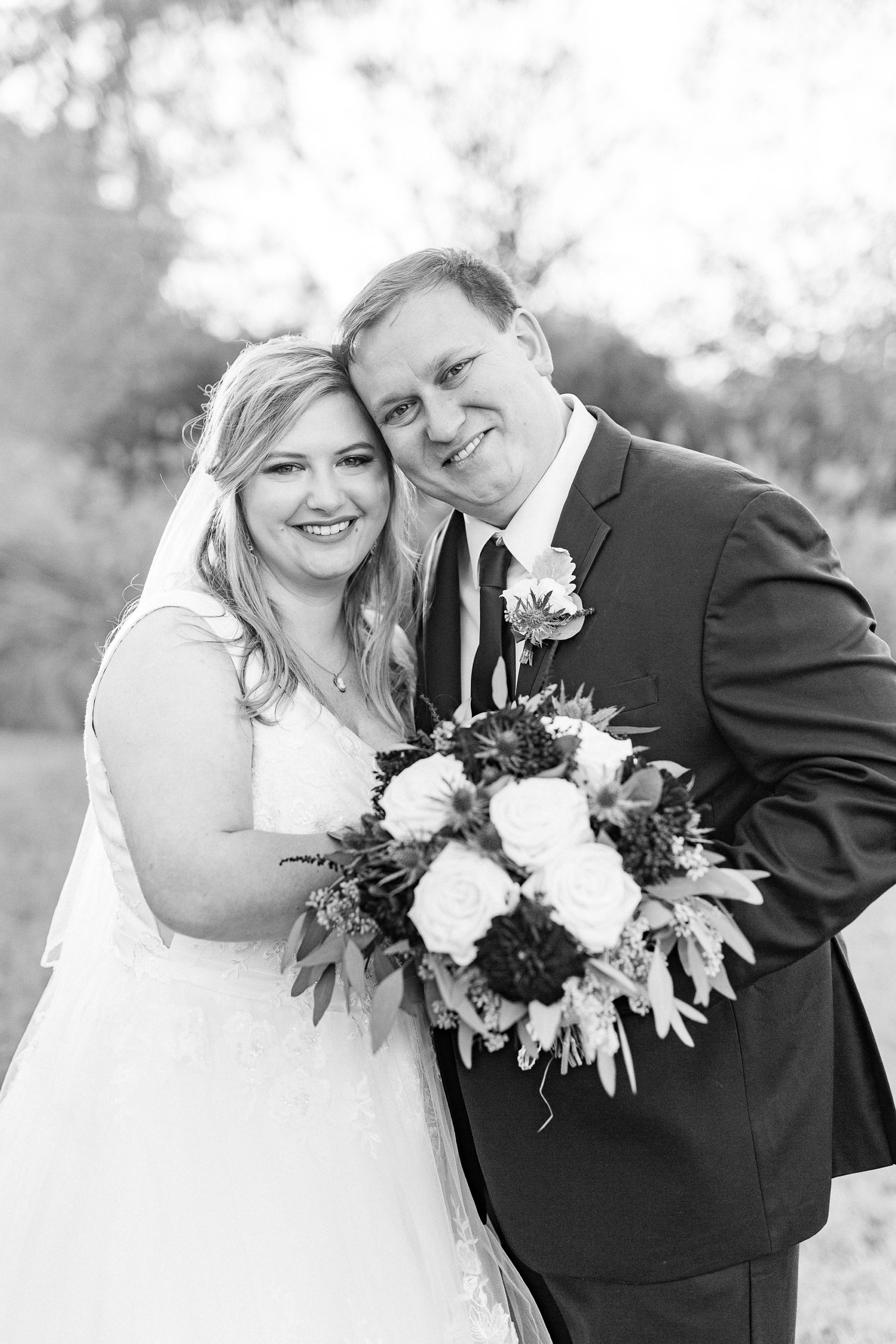 newlyweds pose behind bride's bouquet
