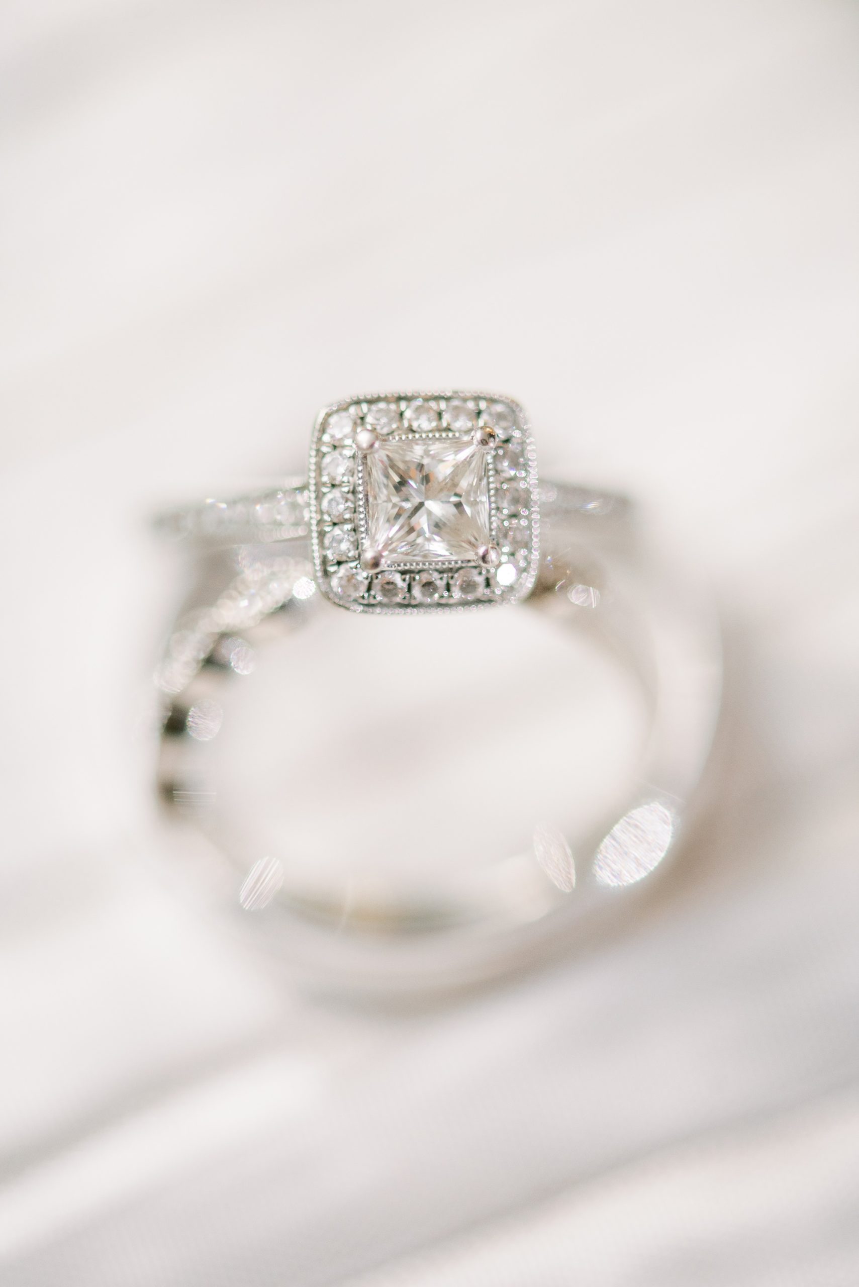 bride's diamond ring sits on veil