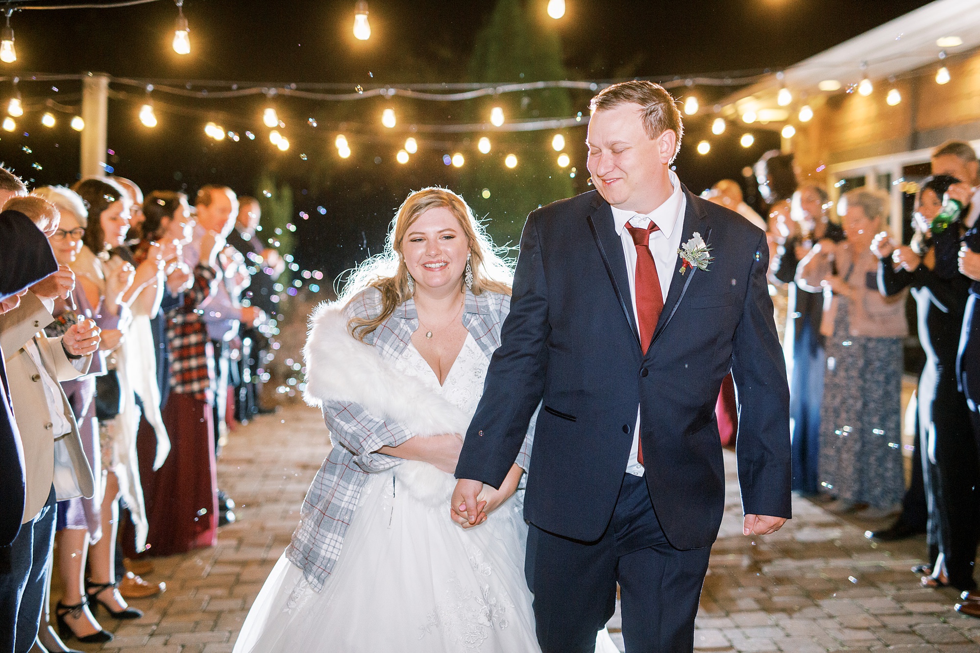 bride in plaid shirt and shawl leaves wedding reception with groom