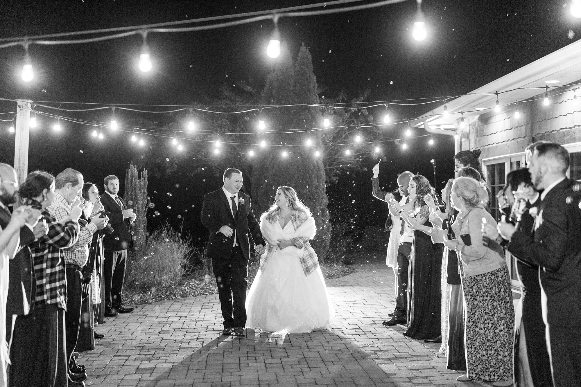 bride in plaid shirt and shawl leaves wedding reception with groom