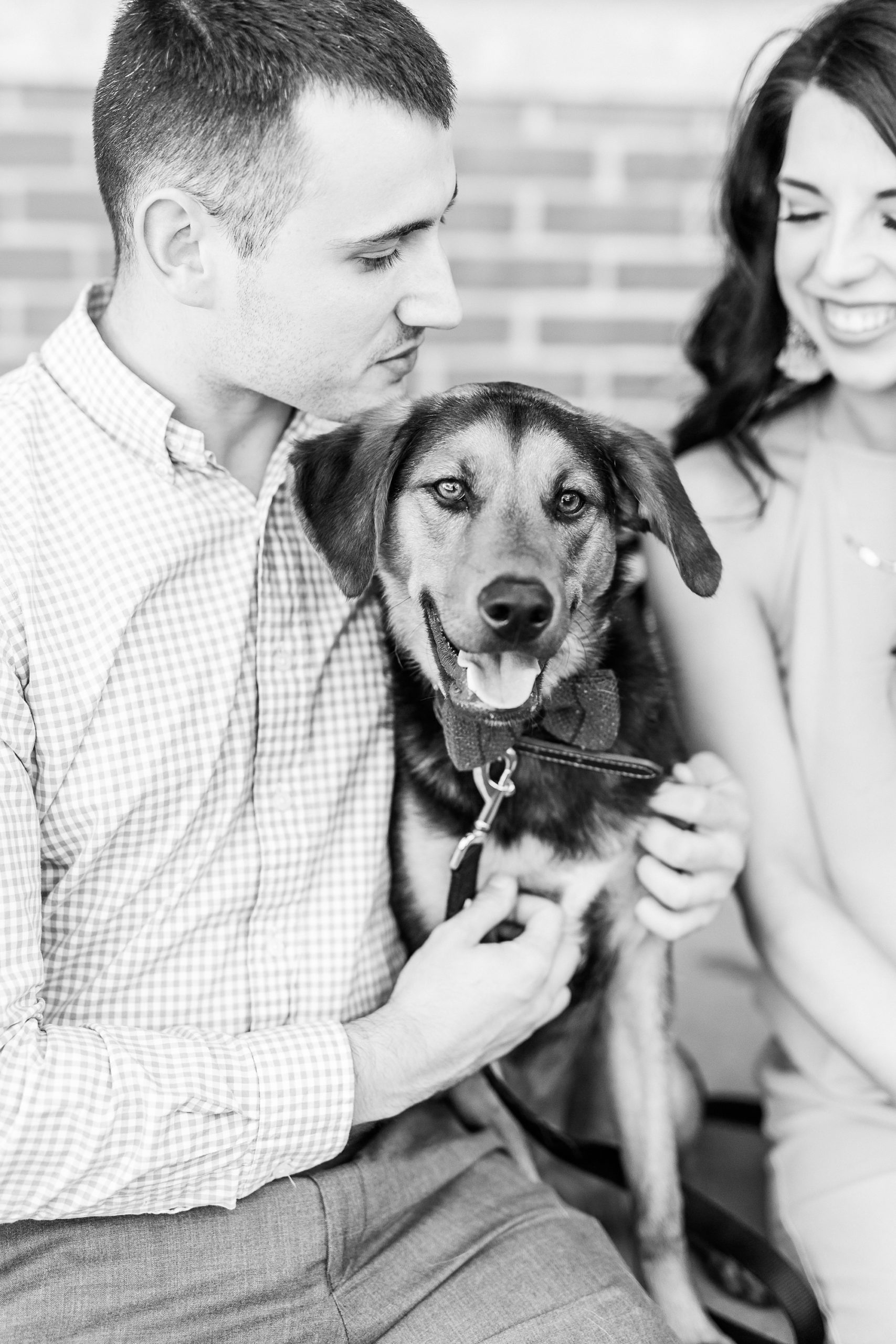 couple hugs dog during Uptown Charlotte NC engagement photos
