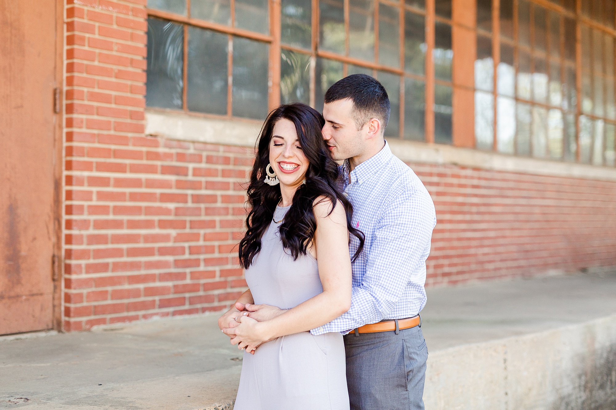 groom whispers in bride's ear from behind during NC photos