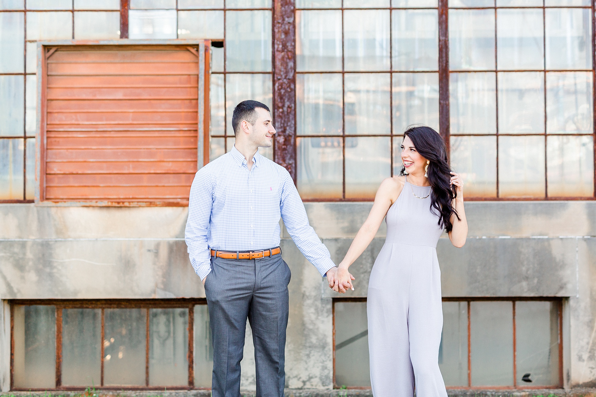 bride and groom hold hands and walk from loading dock in Camp North End