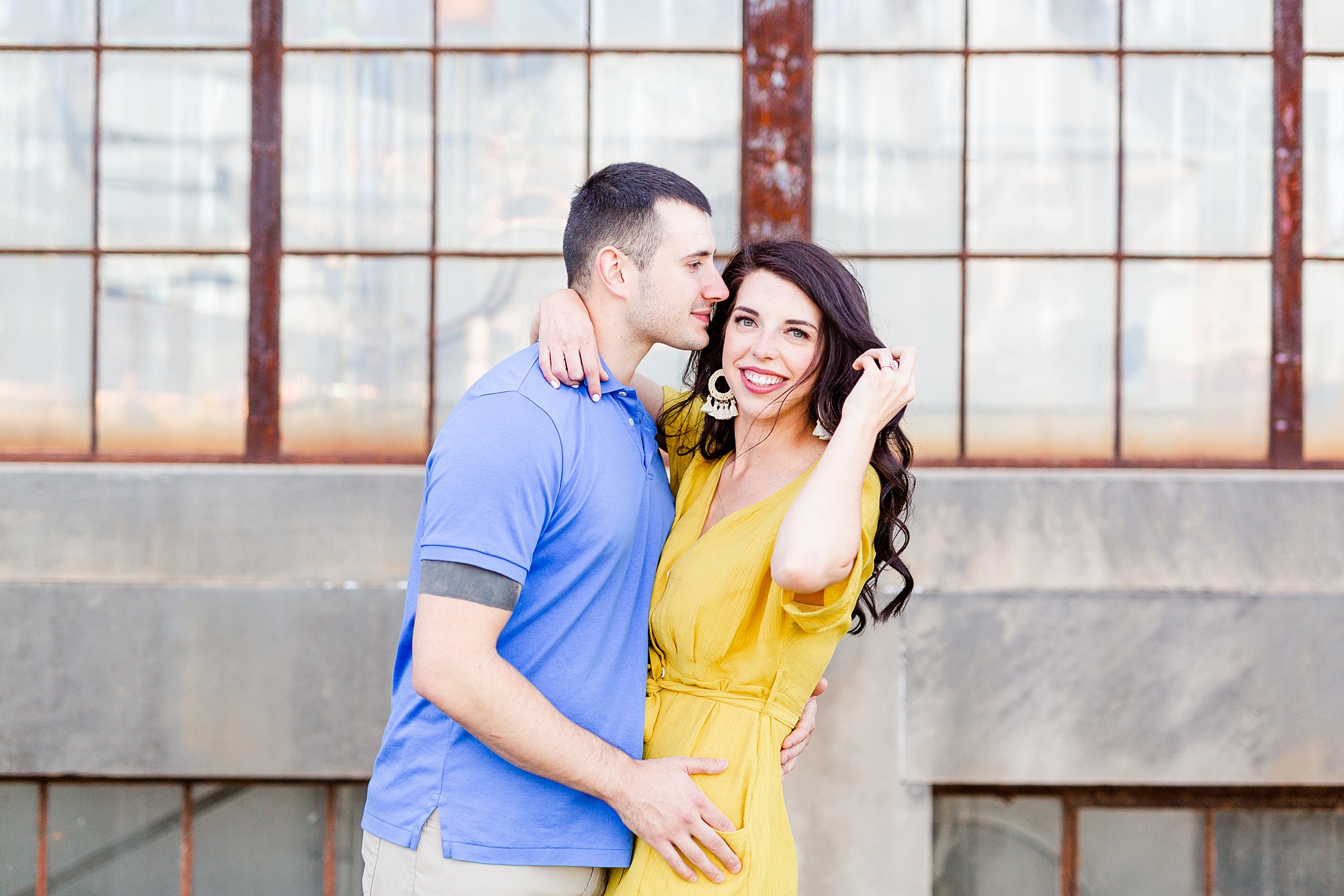 bride holds hair back while groom kisses forehead