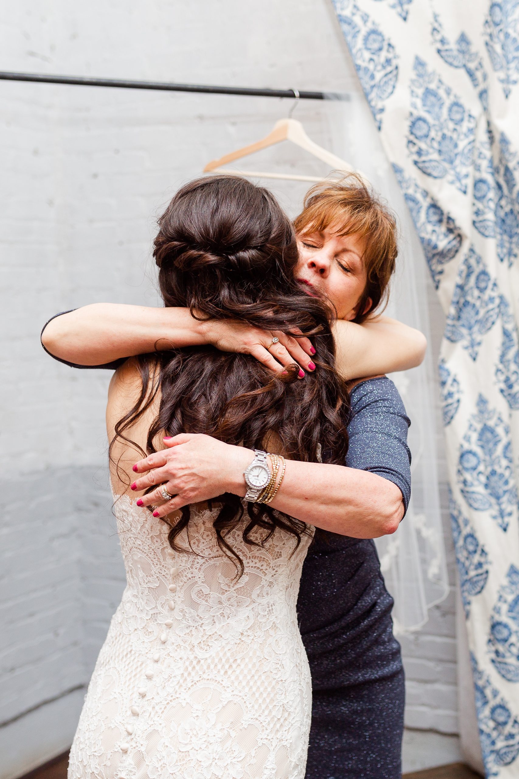 mother of bride hugs bride during NC wedding prep