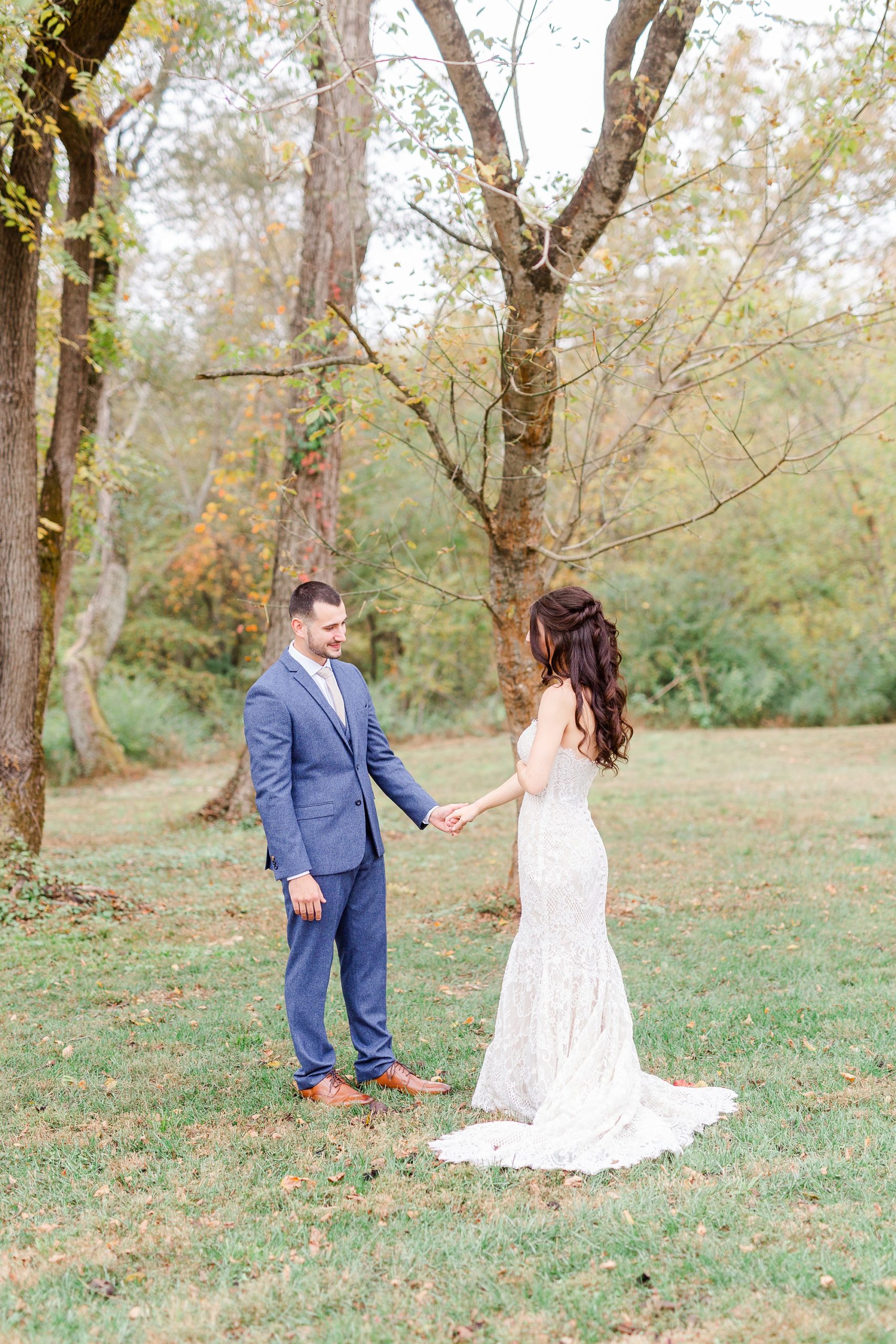 groom looks at bride's wedding dress