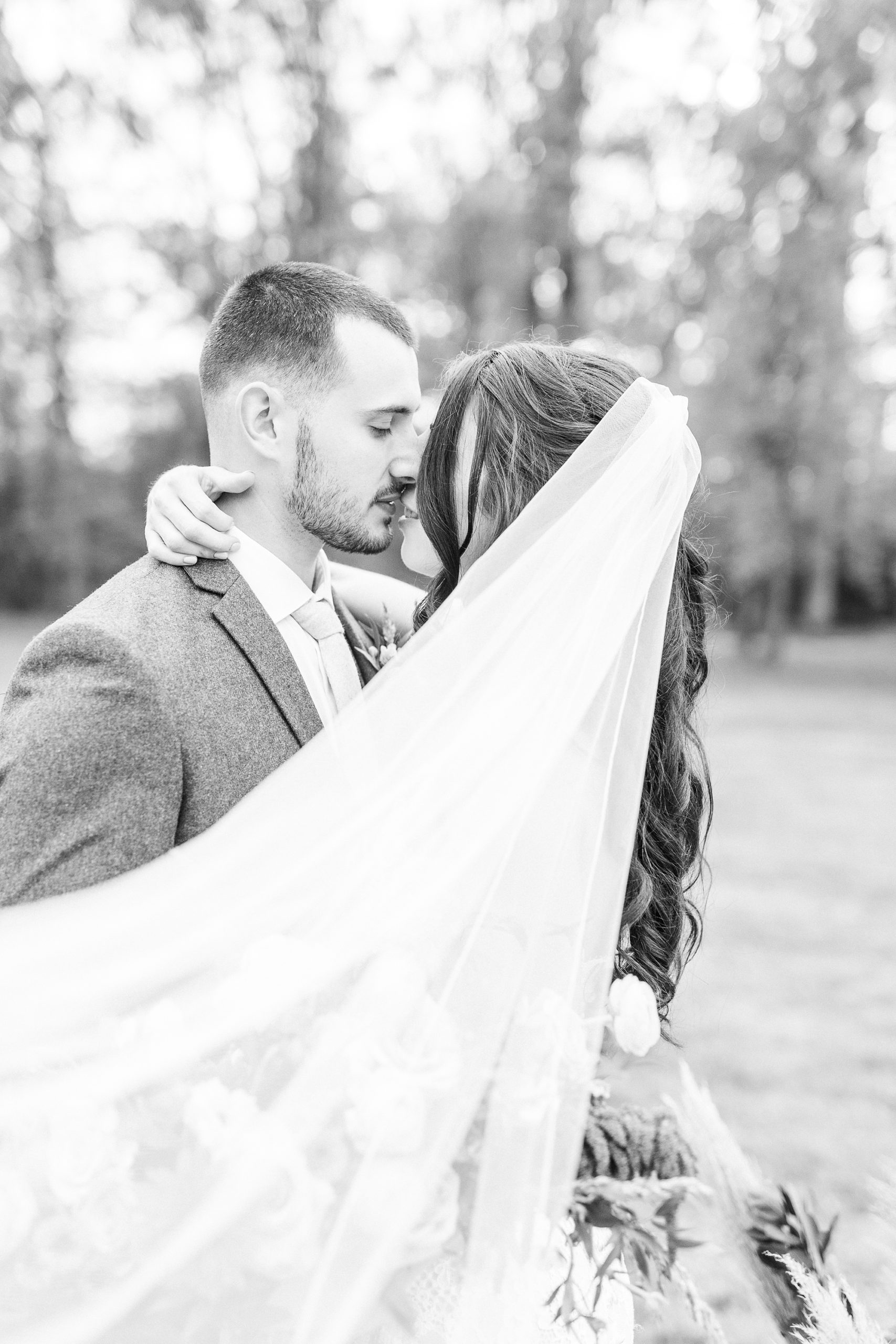 newlyweds kiss with veil floating