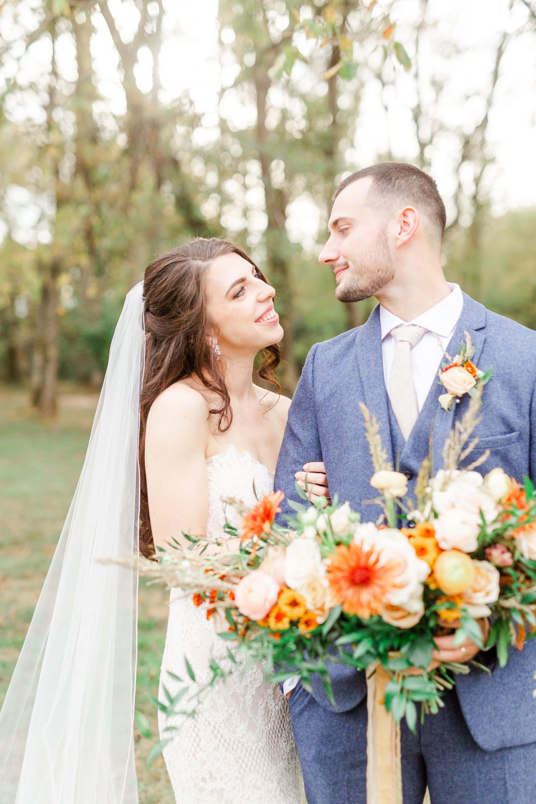 bride holds groom's arm during wedding photos