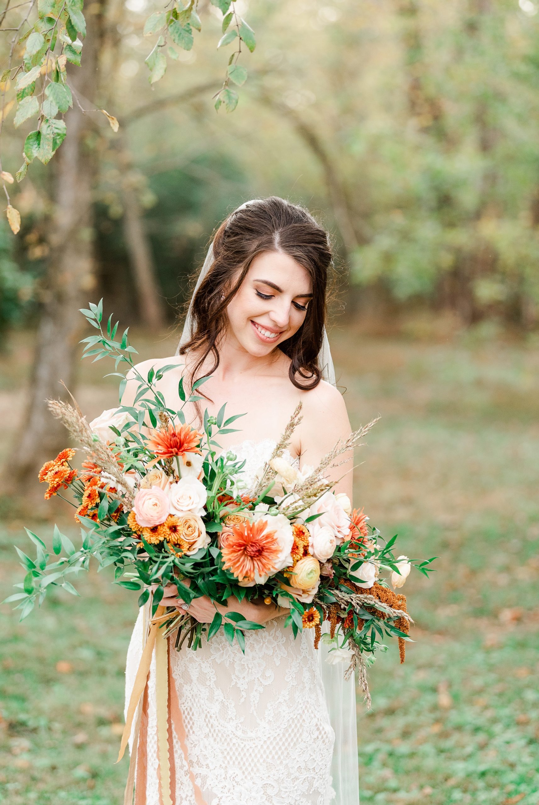 bride holds bouquet of orange and white flowers