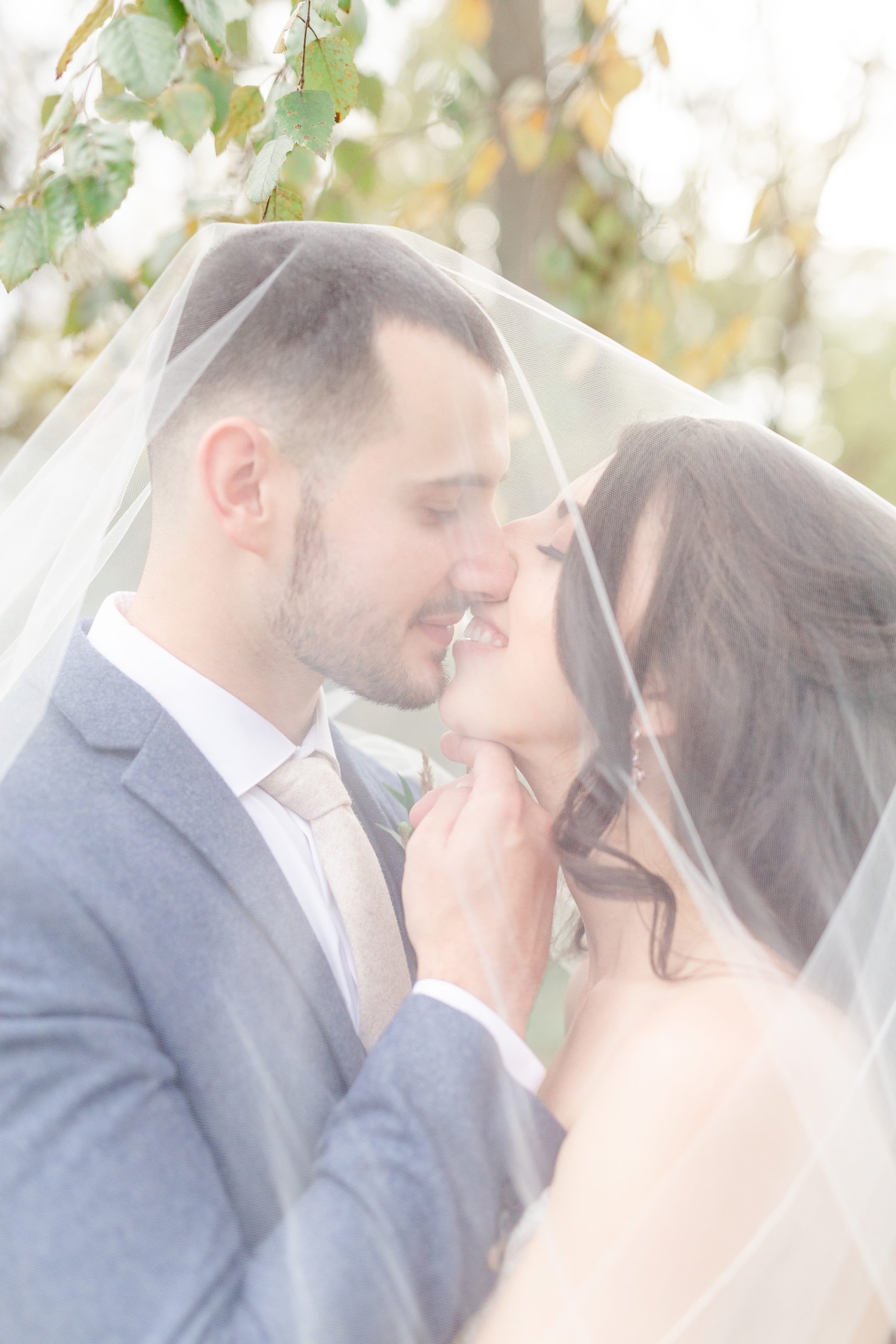 newlyweds almost kiss under bride's veil