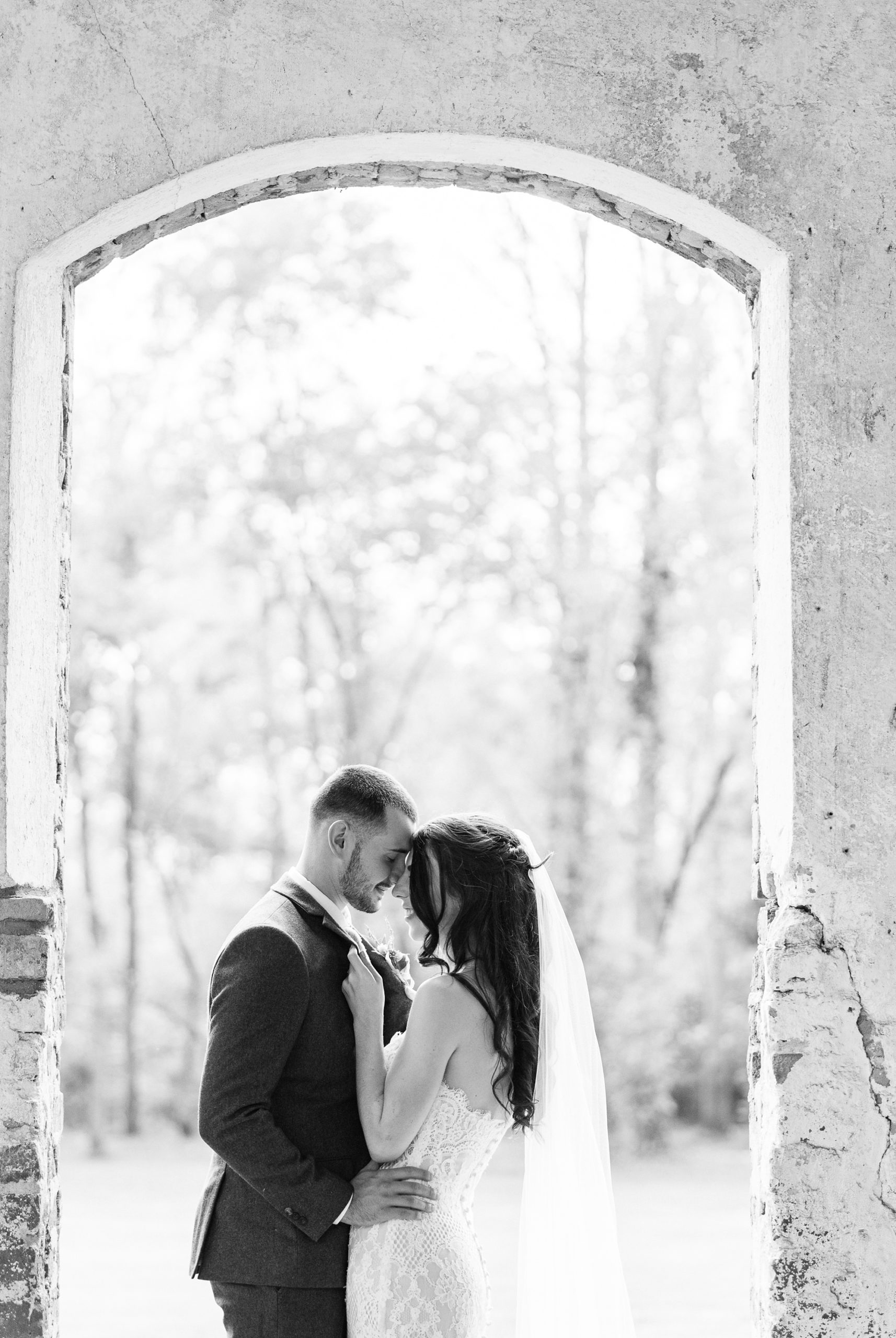 newlyweds pose in tall windows at Providence Cotton Mill