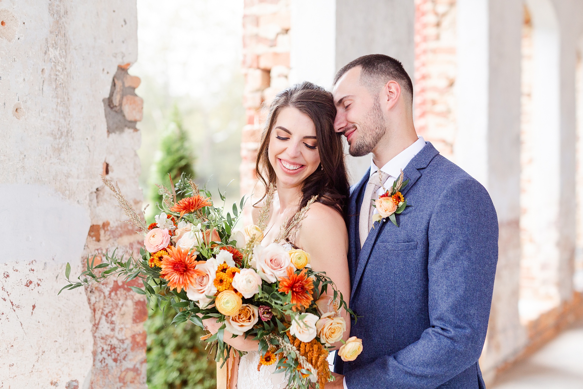 bride and groom lean against brick wall at Providence Cotton Mill