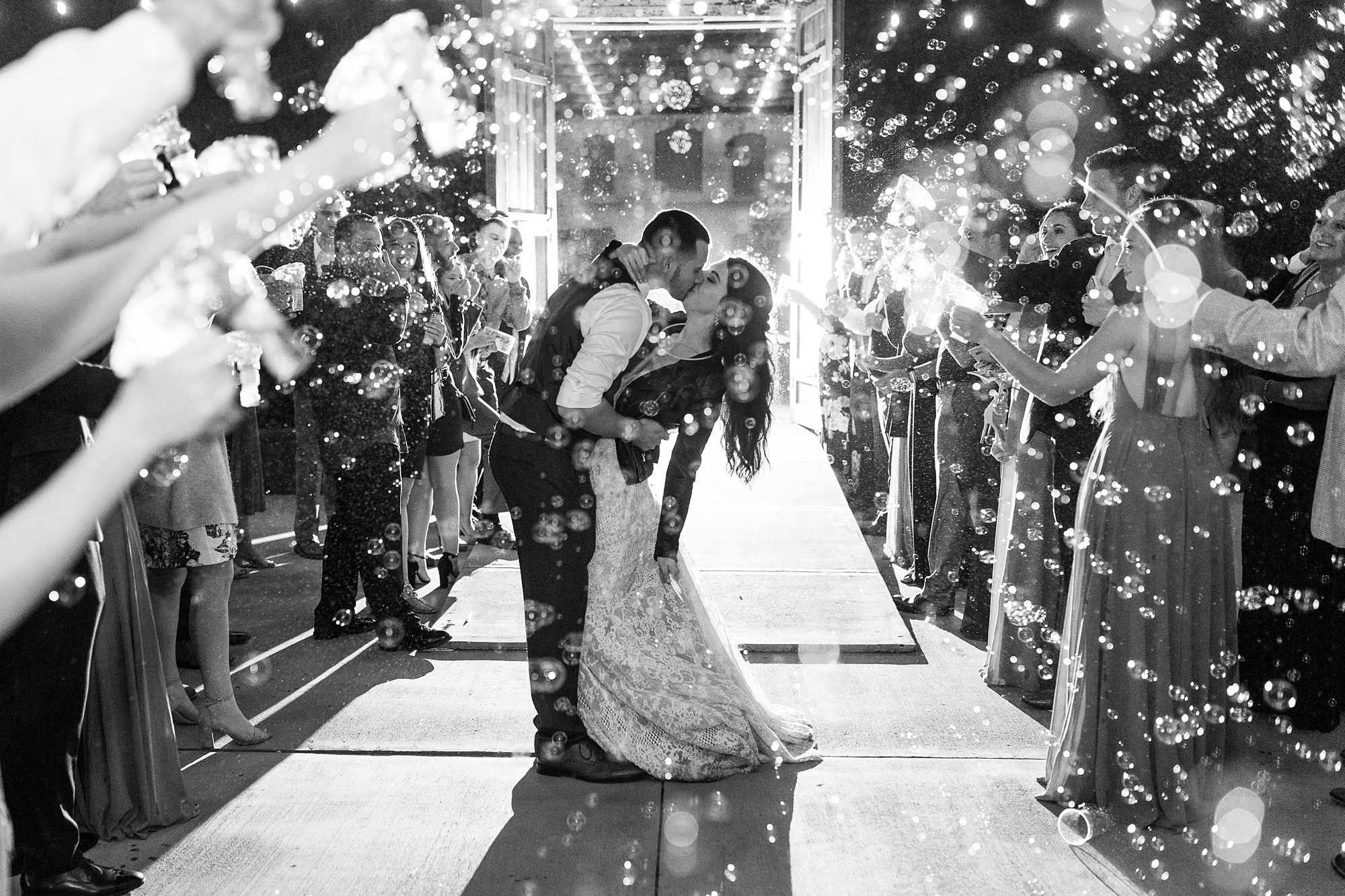 bride and groom kiss during bubble exit from Providence Cotton Mill