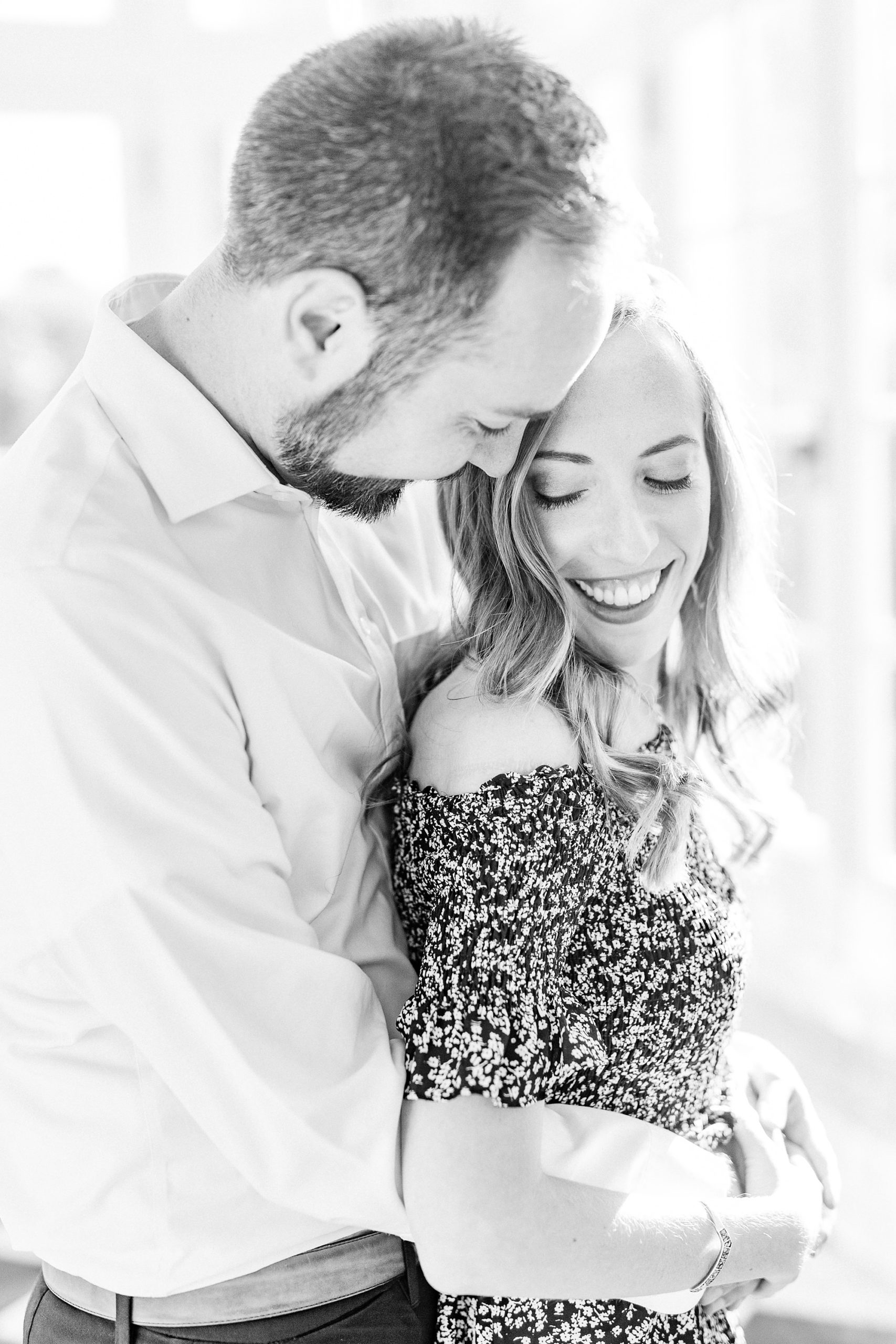groom hugs bride from behind and smiles