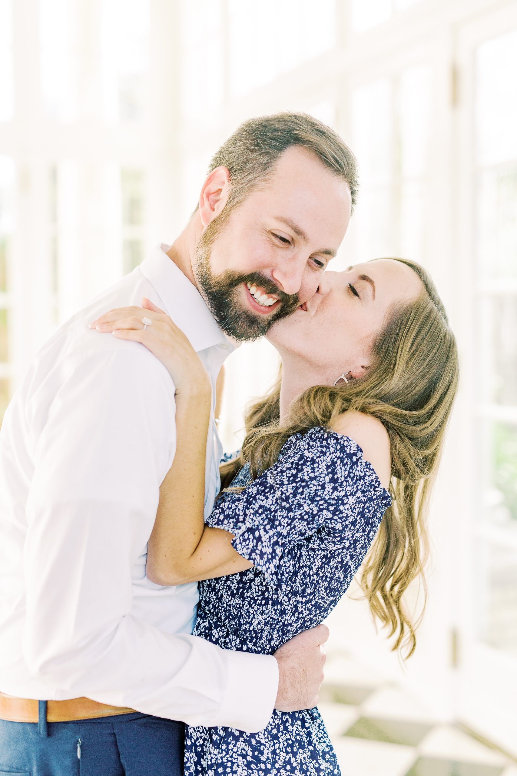 bride leans up to kiss groom's cheek during Separk Mansion engagement session