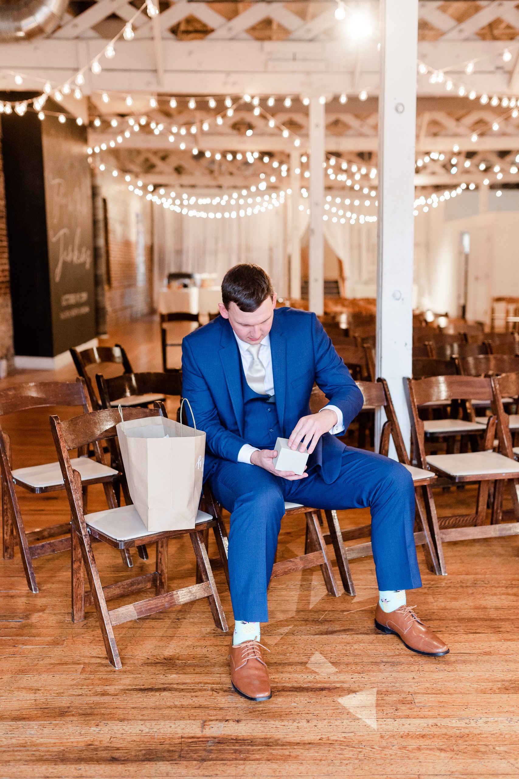 groom opens gift from bride on wedding day