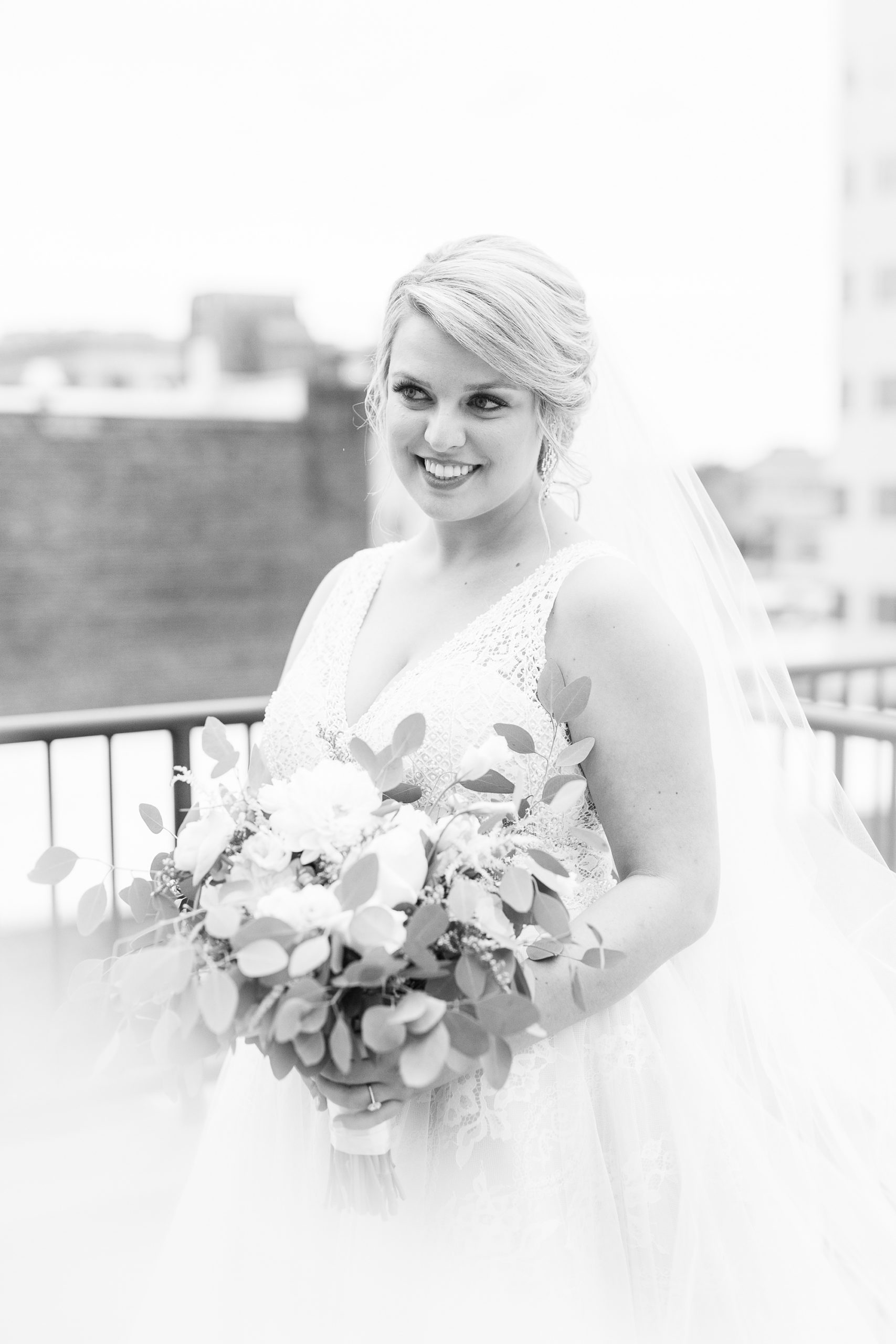 bride holds bouquet with veil floating around her