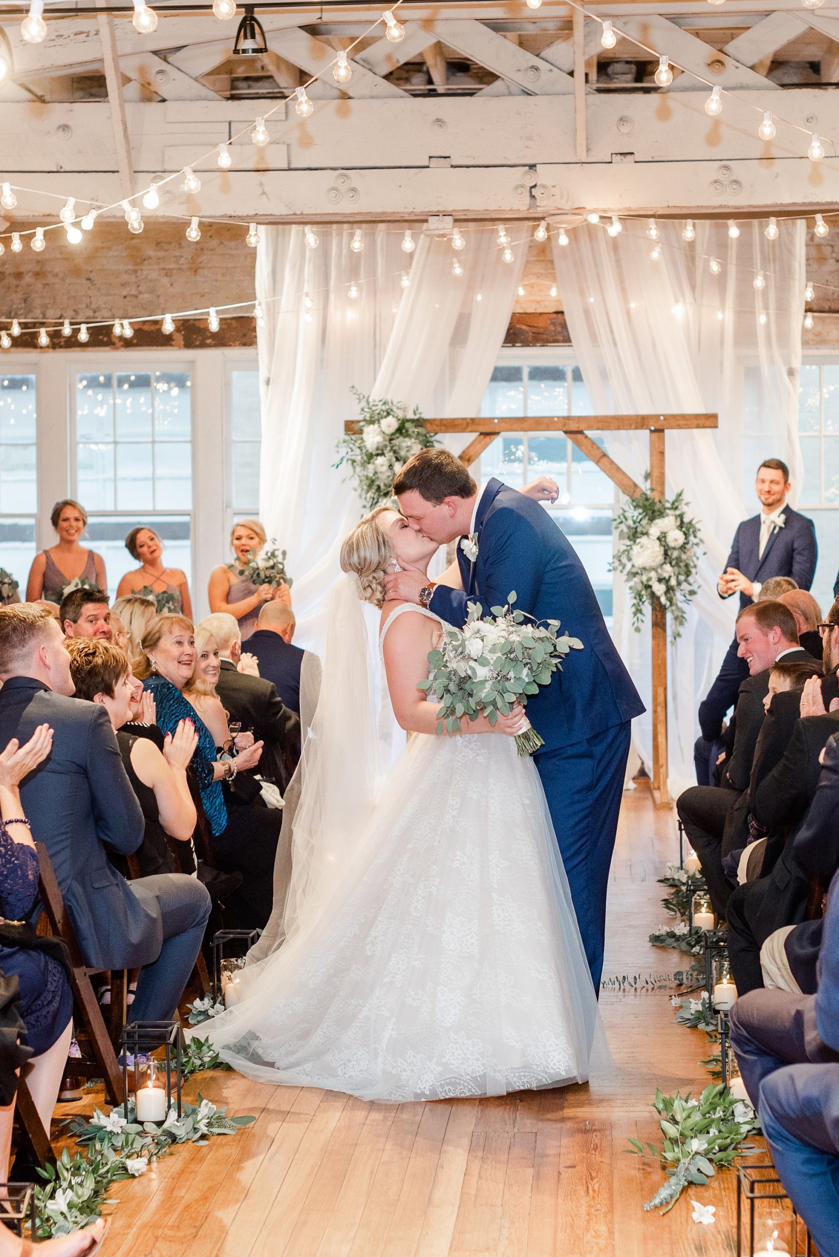 newlyweds kiss while walking up aisle in Raleigh NC