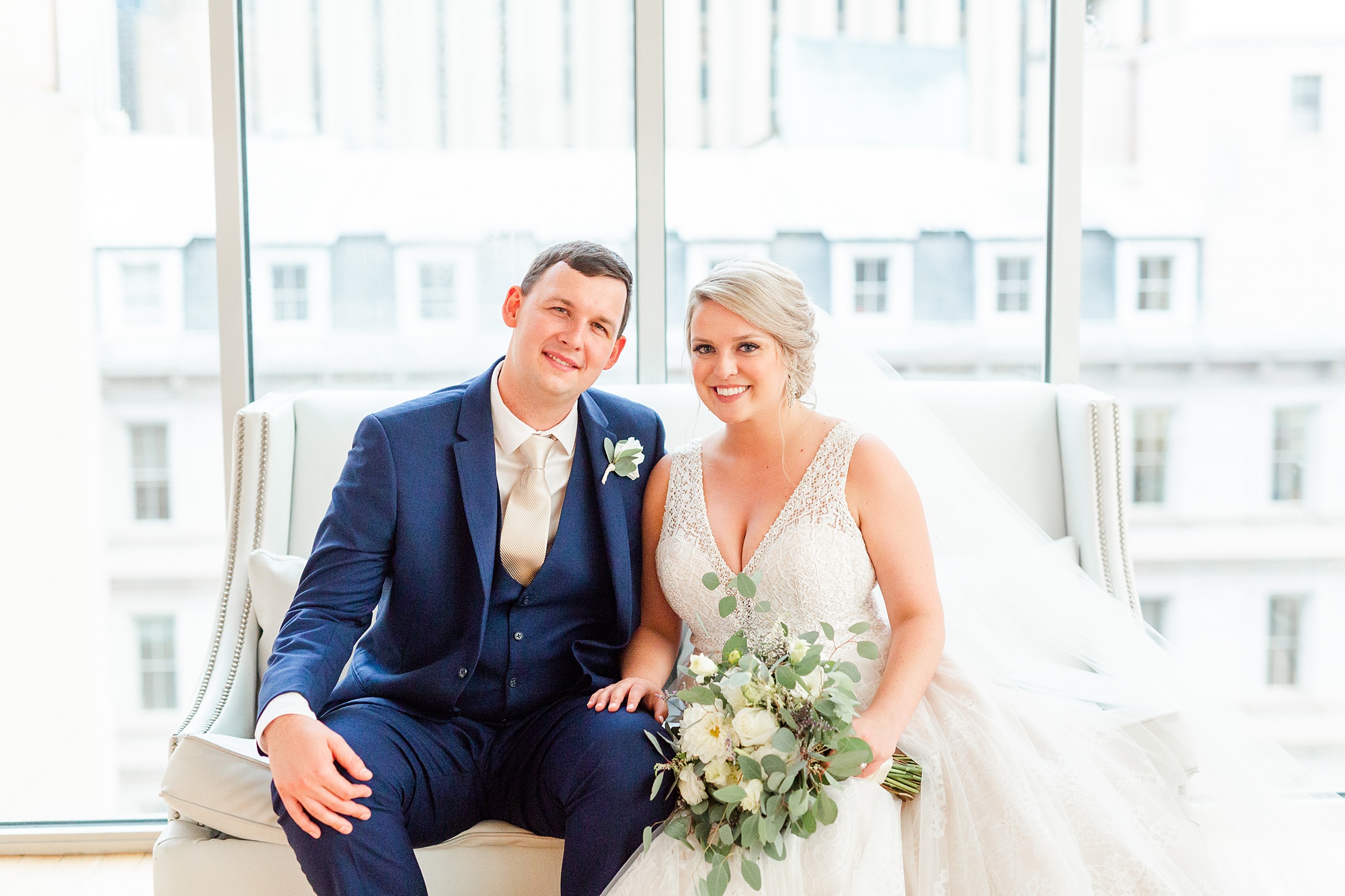 newlyweds pose on couch by window at Stockroom at 230