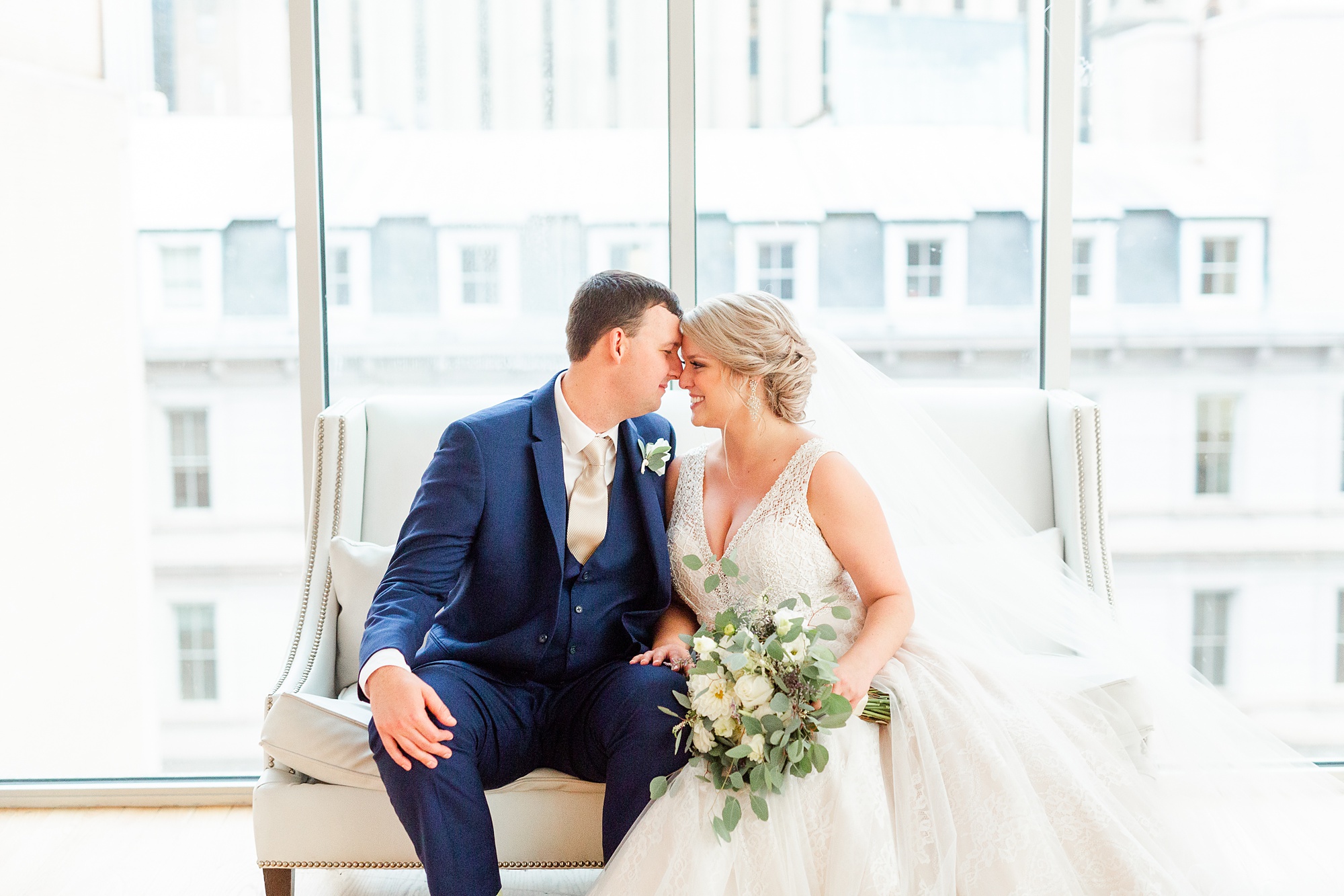 bride and groom pose together on couch in Raleigh NC