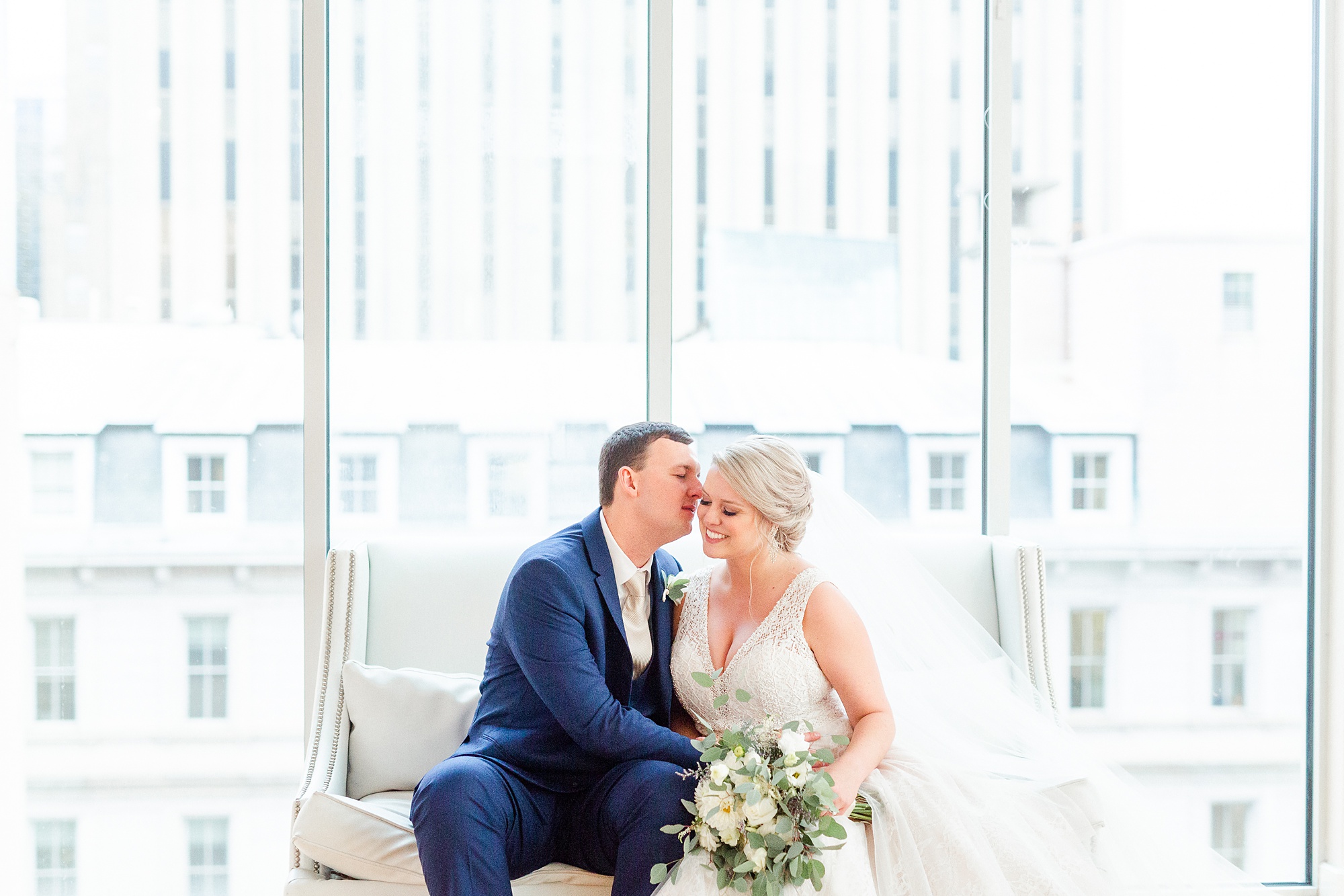 newlyweds sit on couch at the Glass Box