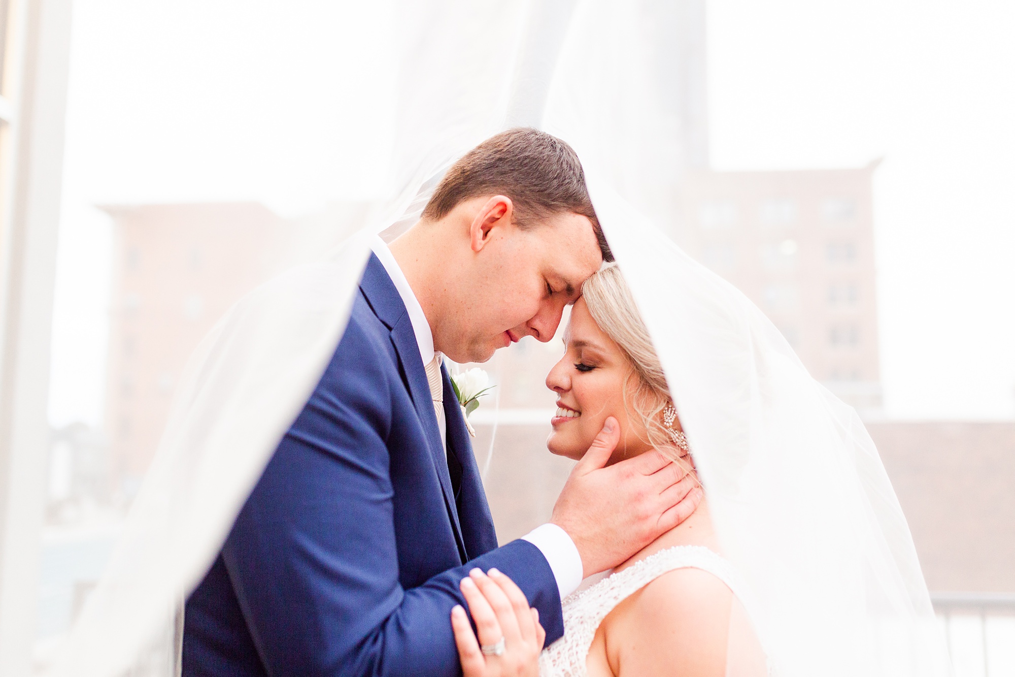 bride and groom pose under veil at the Stockroom at 230