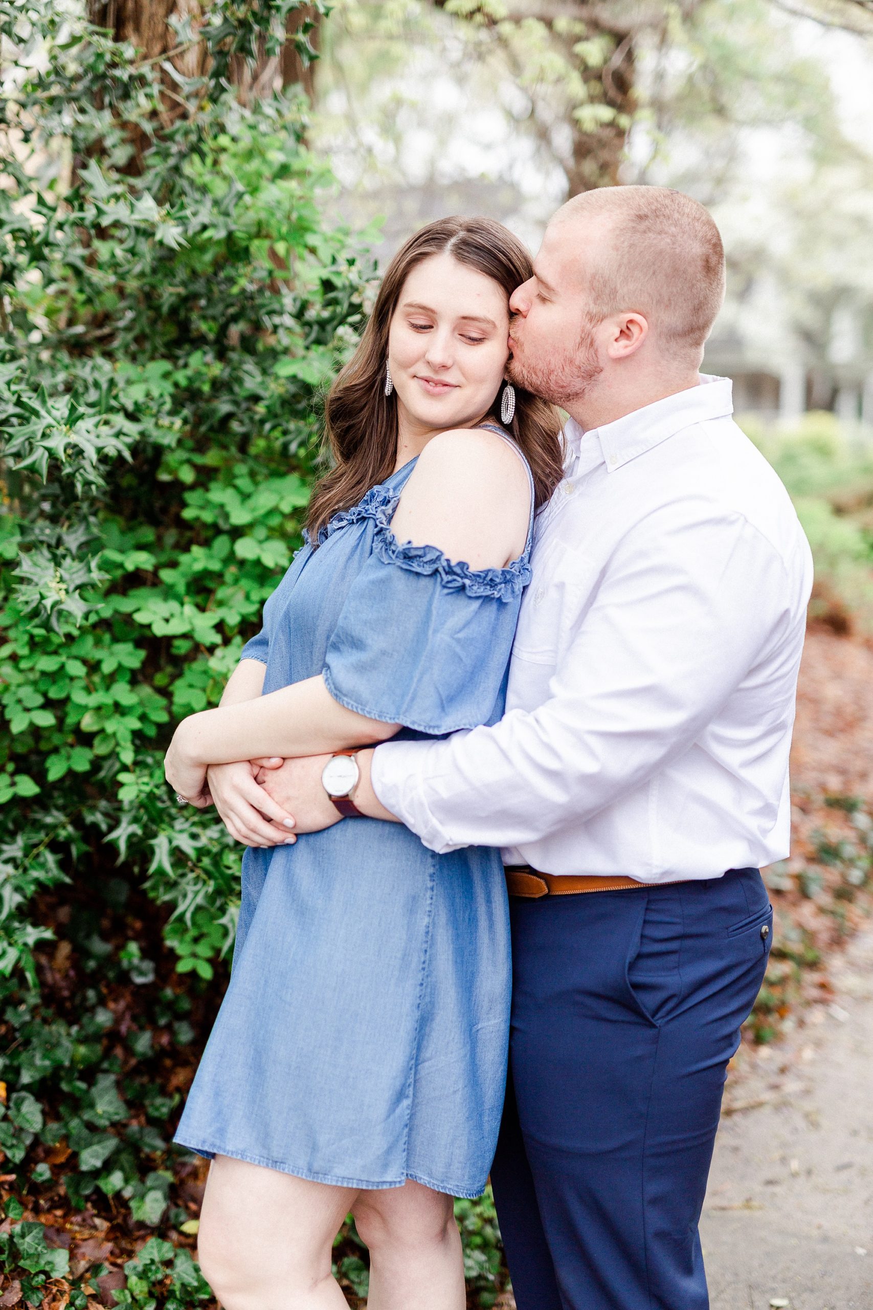 groom kisses bride during engagement photos in the spring