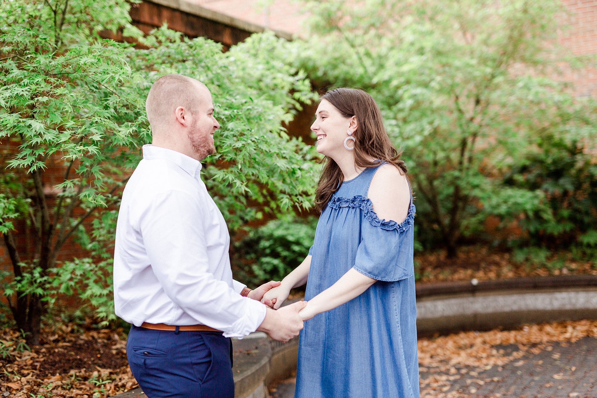 bride and groom hold hands standing on sidewalk in Downtown Davidson